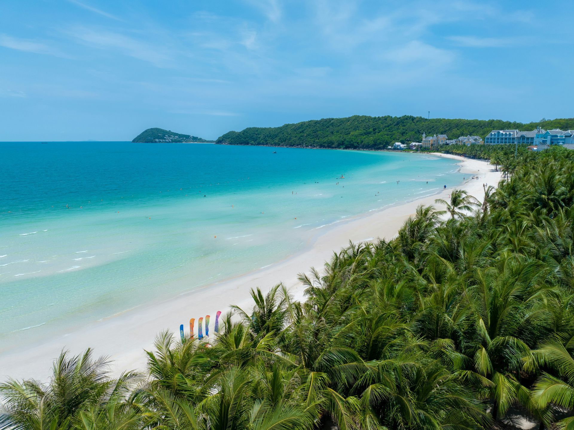 Palm trees frame a white-sand beach and turquoise water in Phú Quốc, Vietnam.