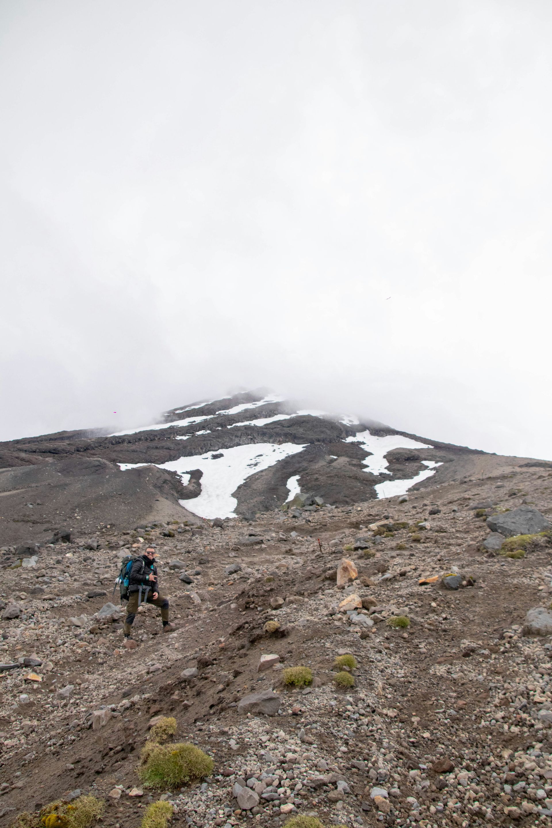 A person with a backpack is hiking up the Mount Taranaki Summit Track, Taranaki, New Zealand.