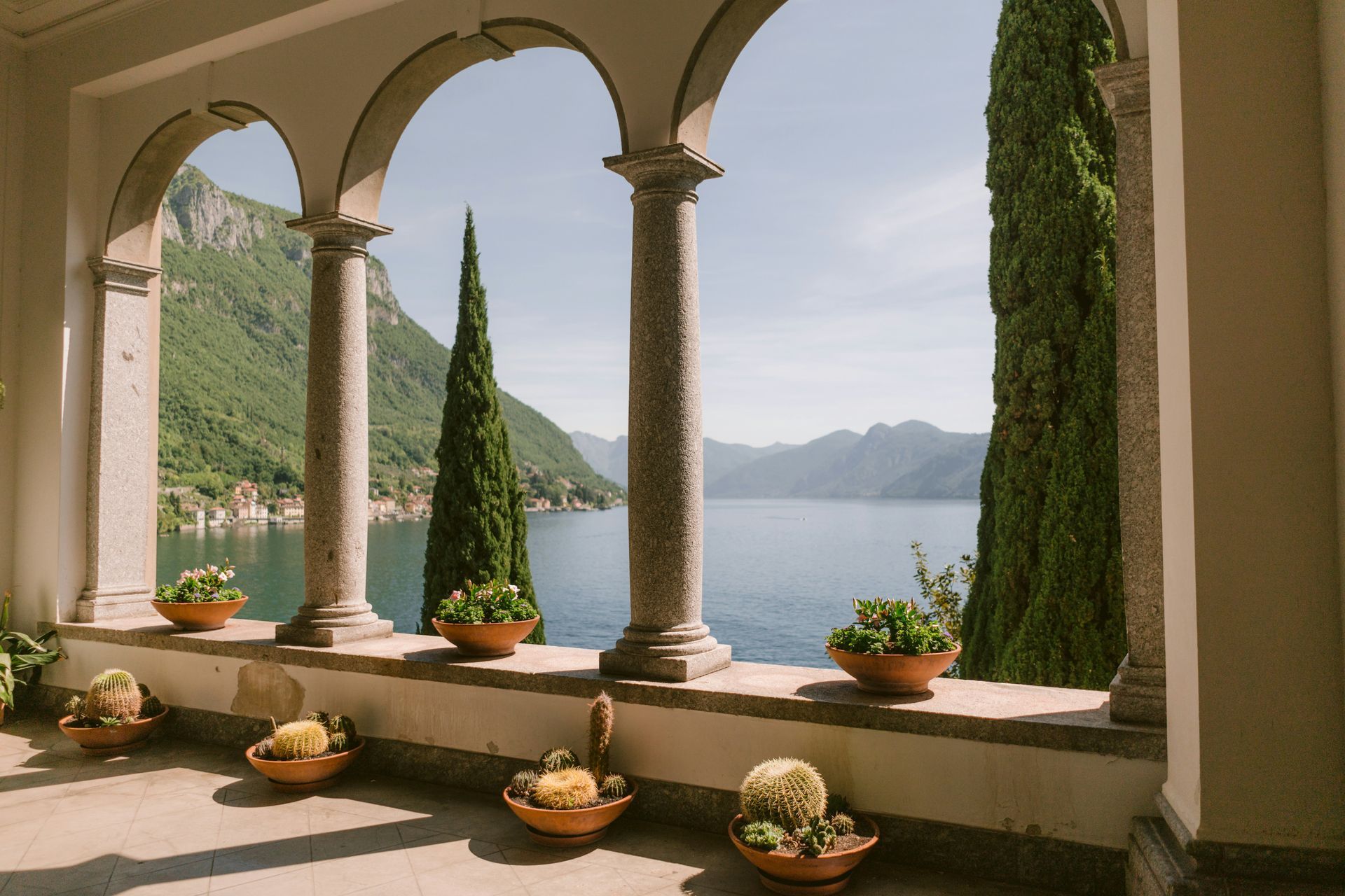A balcony with arches overlooking Lake Como and the mountains in Italy.