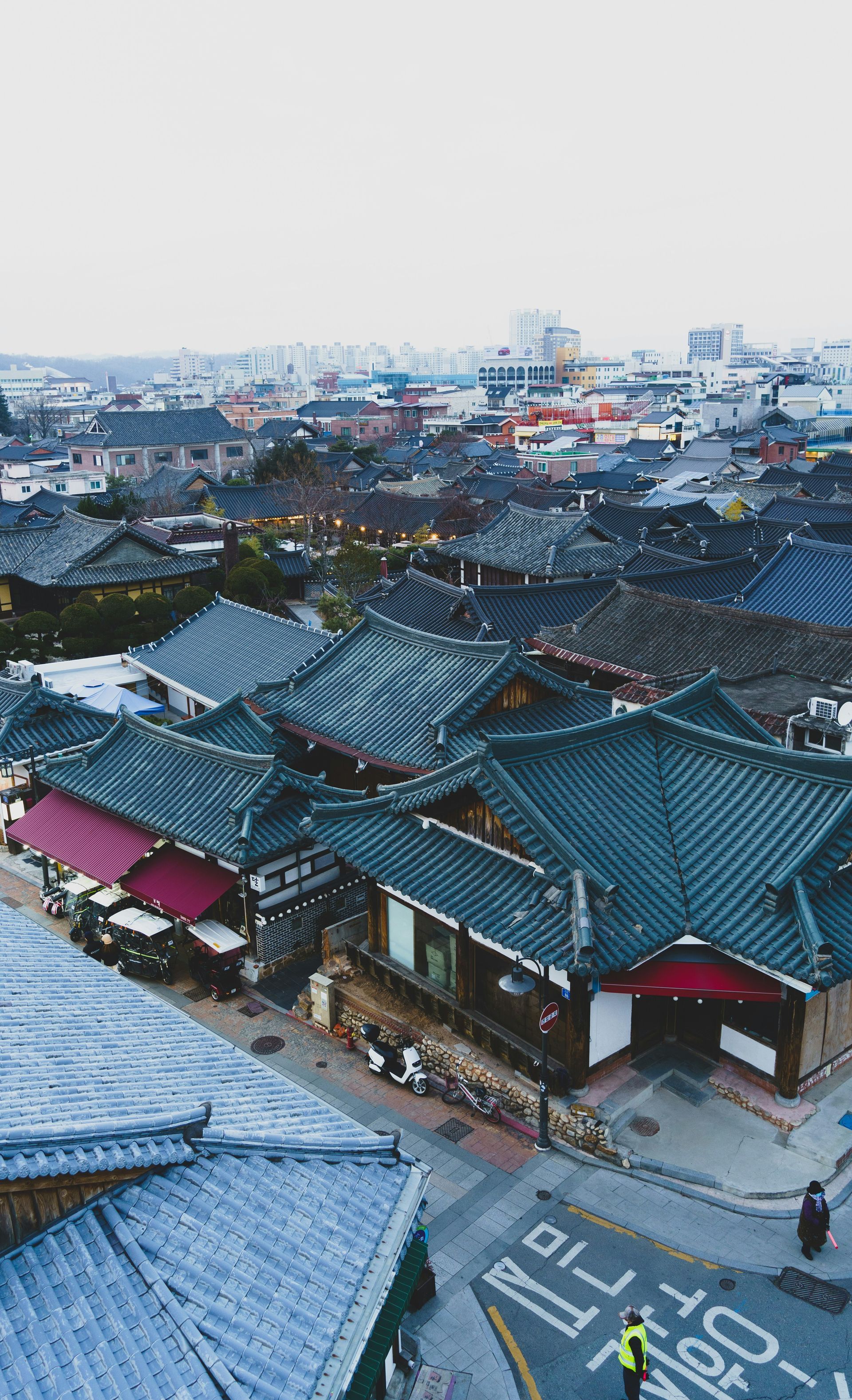 Overhead view of a traditional village of Jeonju Hanok with tiled roofs, shops, and a road in South Korea.