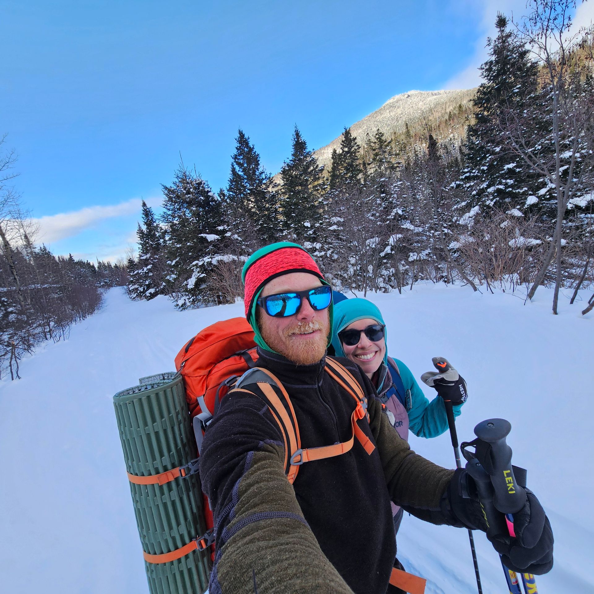 A man and a woman are taking a selfie in the snow