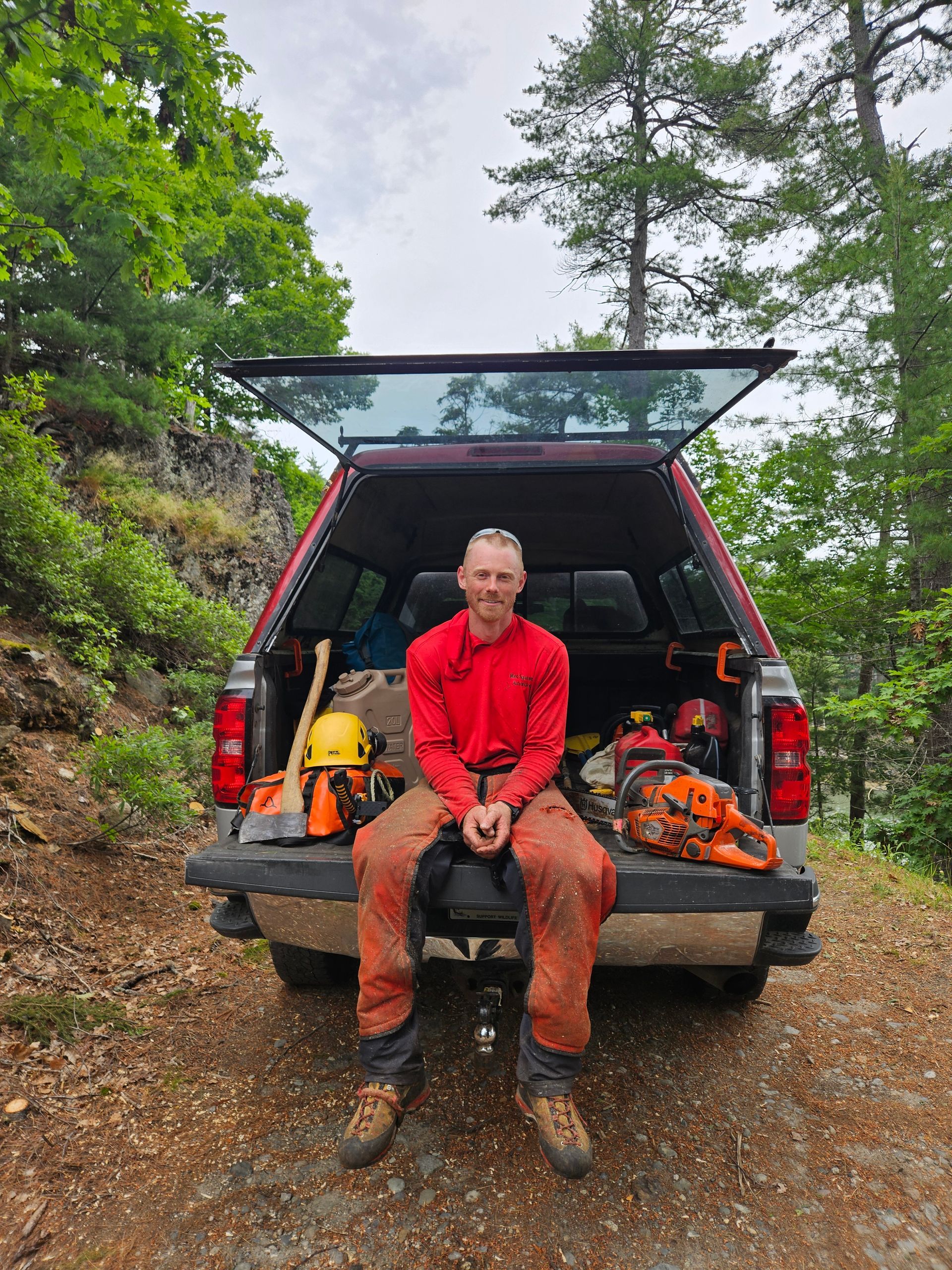 A man is sitting in the back of a truck.