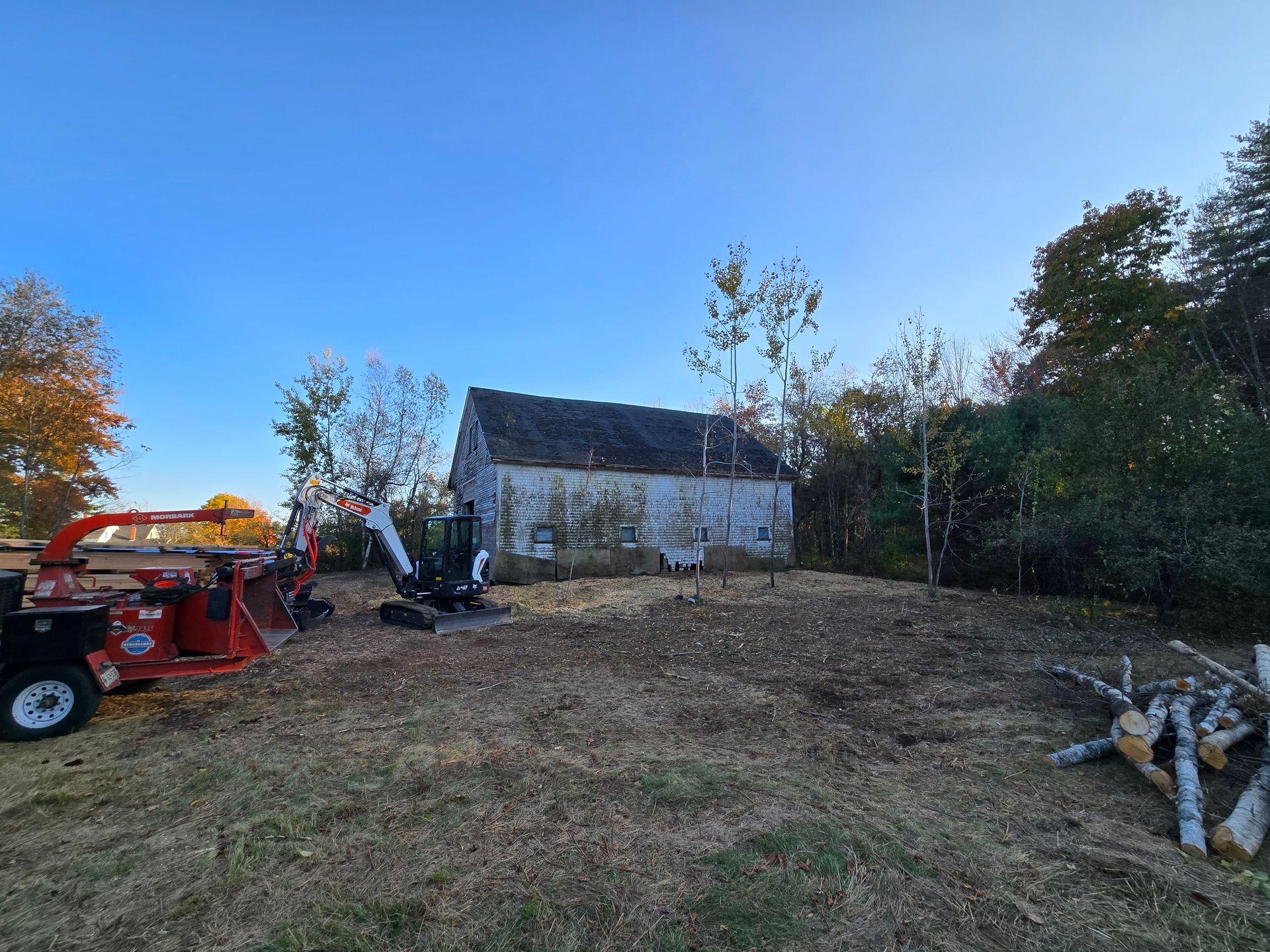 A tractor is parked in a field in front of a house.