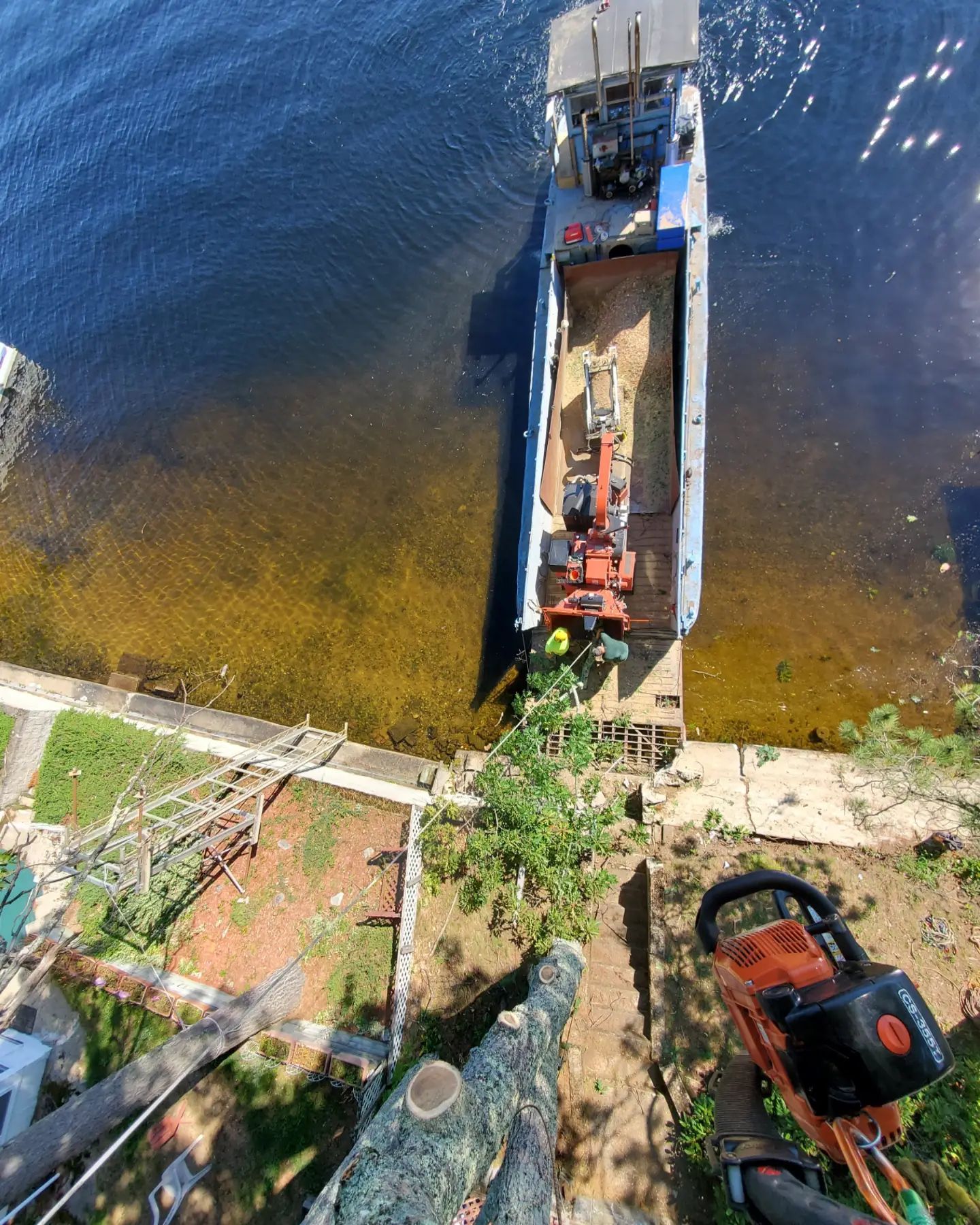An aerial view of a boat in the water next to a chainsaw.