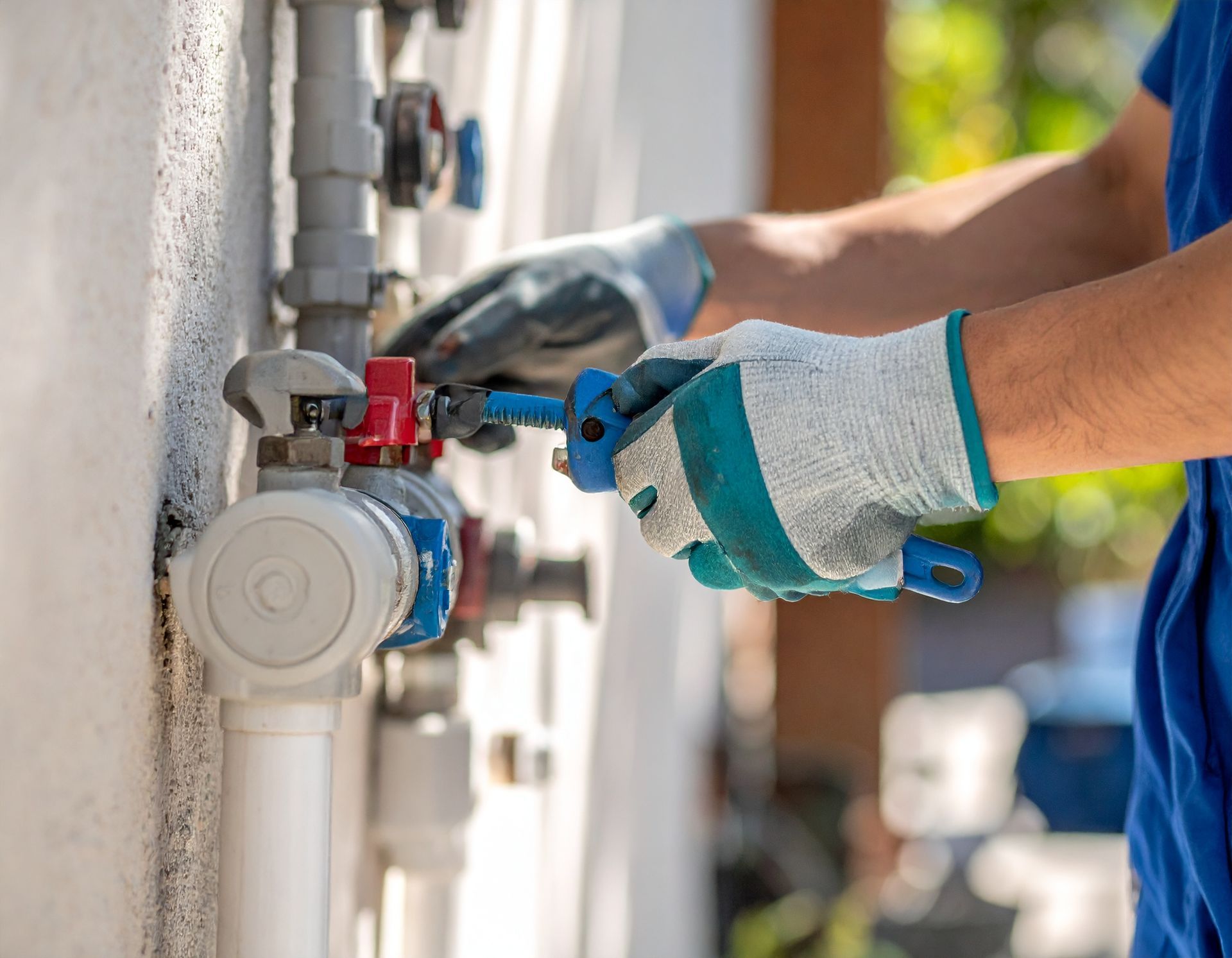 Gloved technician turning a valve on a gas meter outdoors