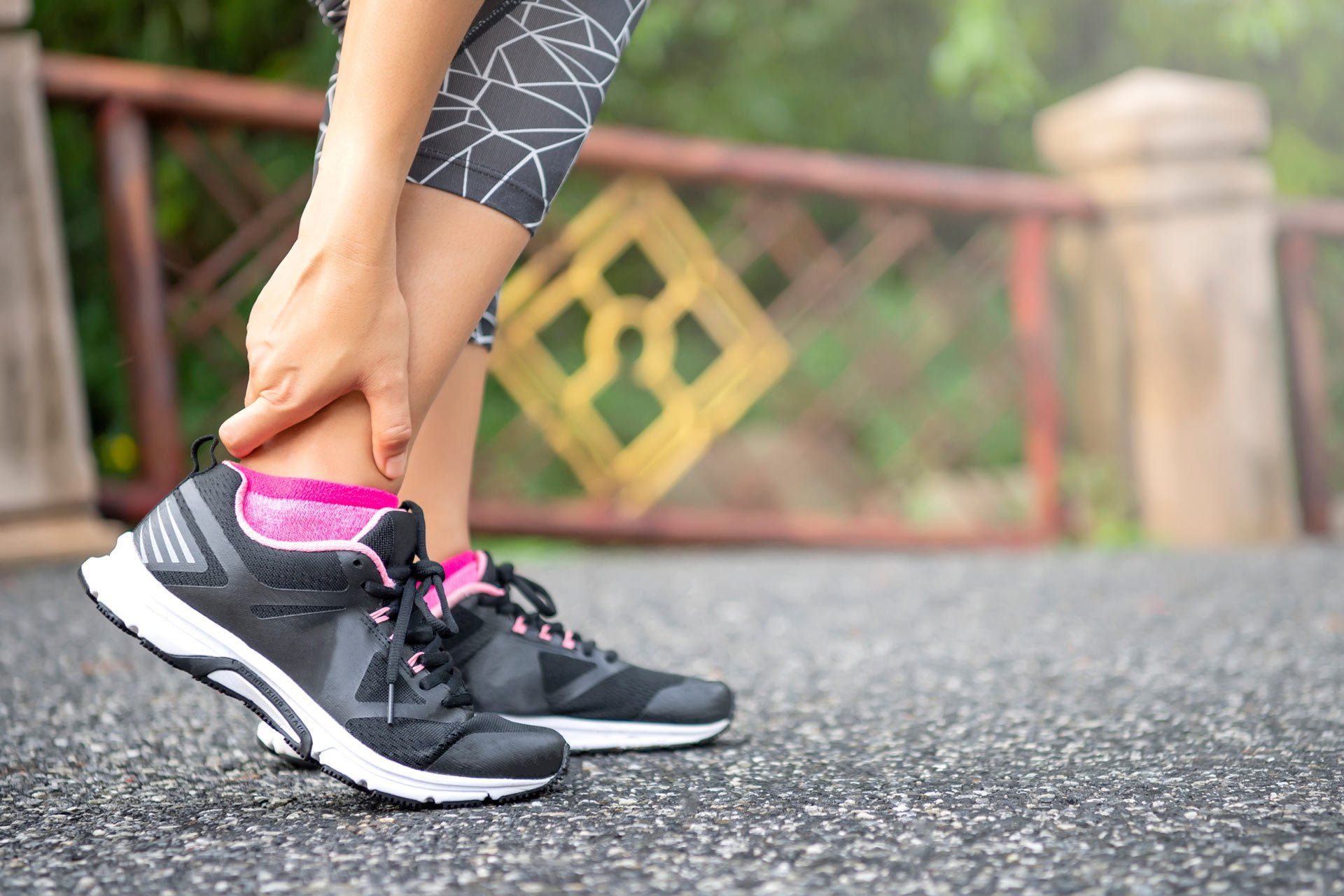 Close-Up Asian Woman Standing on Road Holds Her Ankle Injury After Jogging | Central Coast, Nsw | Angela Green Podiatry