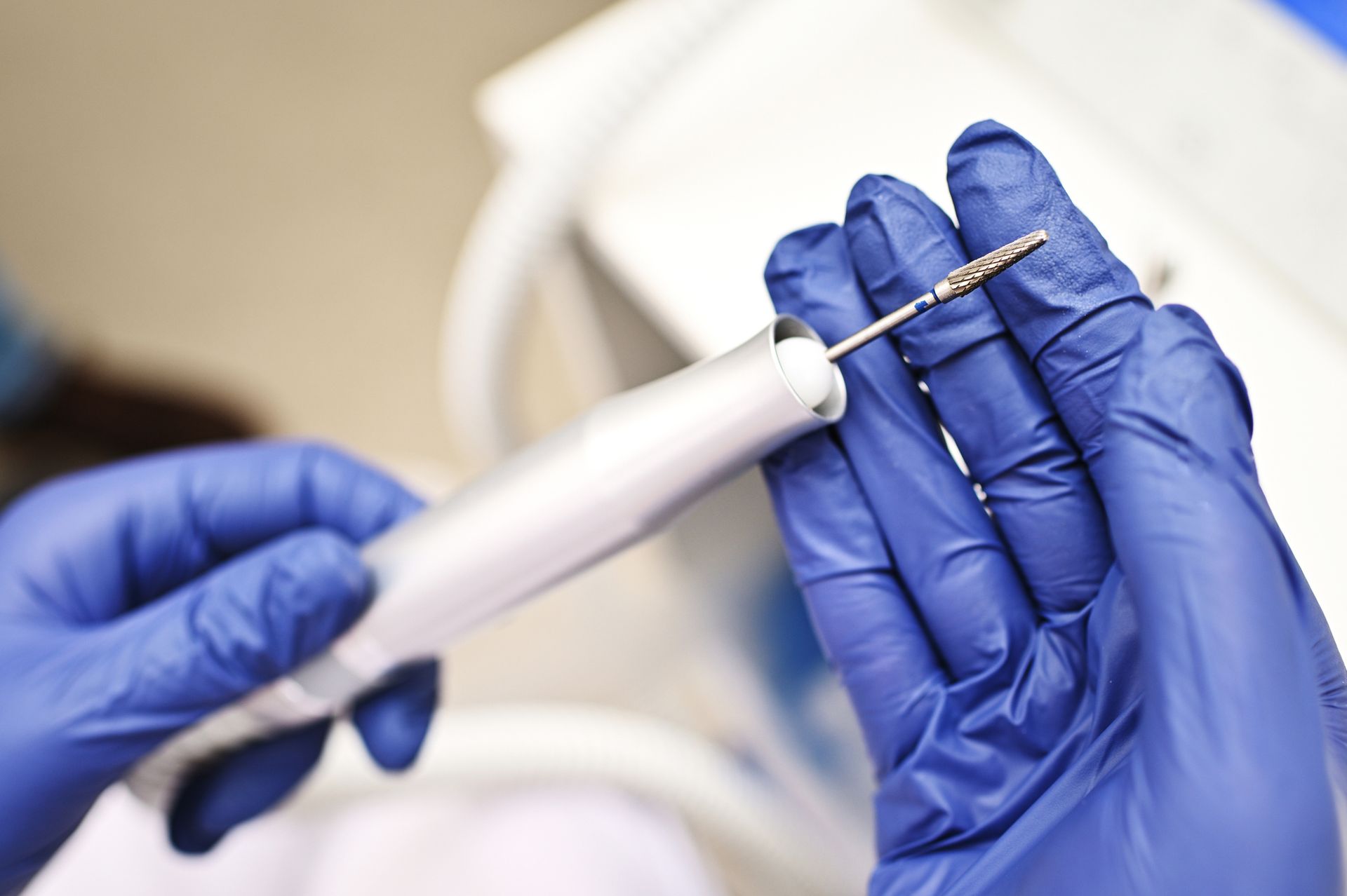 A podiatrist in rubber gloves holding a device, highlighting podiatry surgical supplies.
