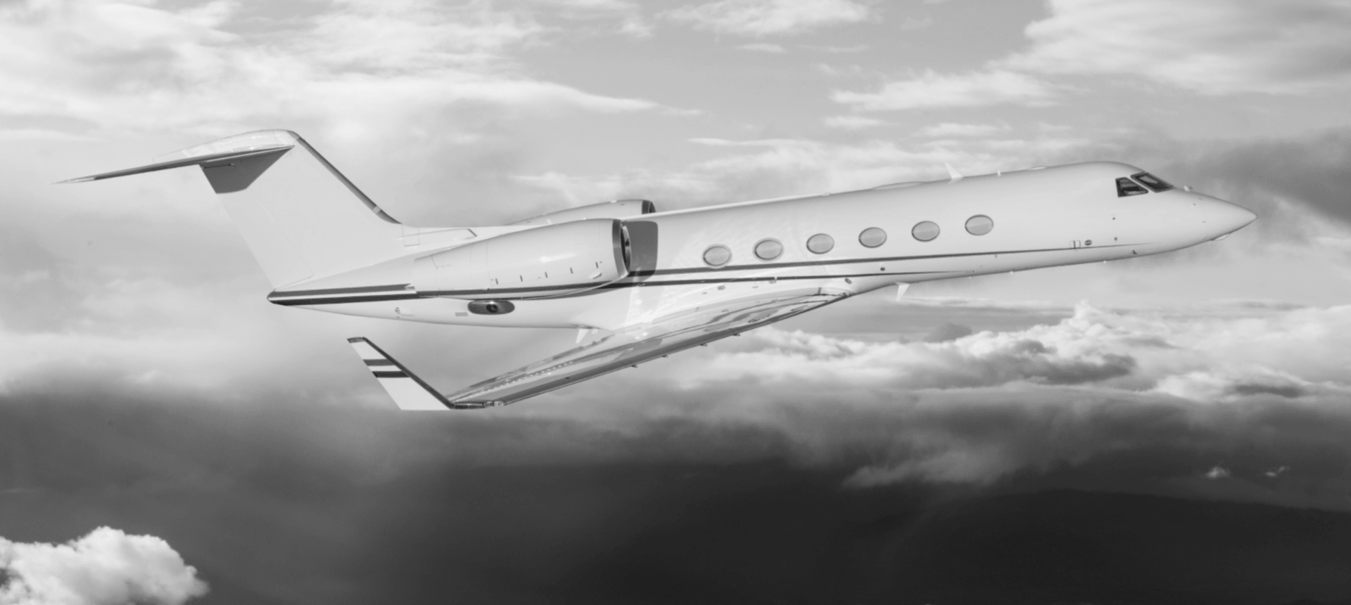 A private jet is flying through the clouds in a black and white photo.