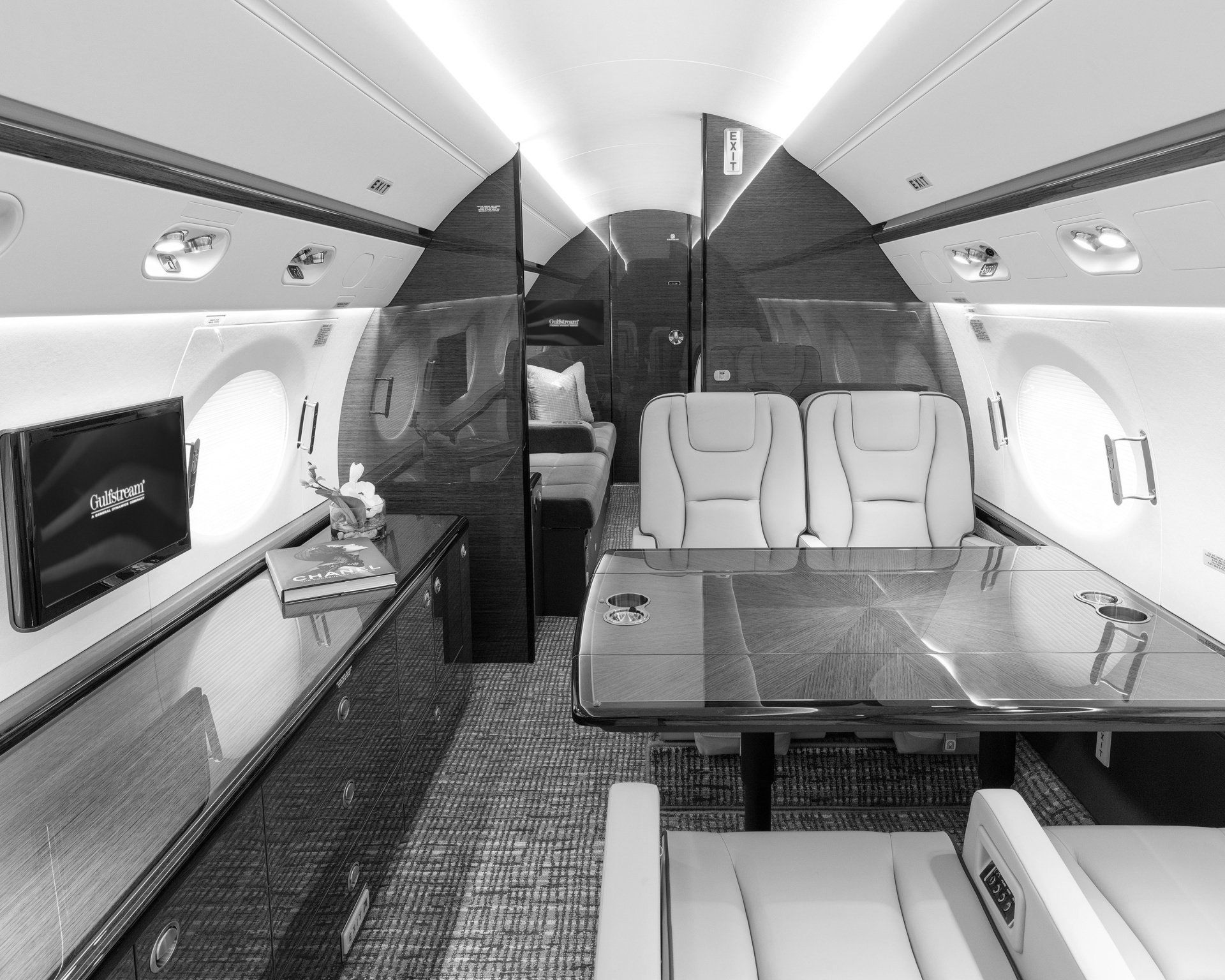 The inside of a private jet with a table and chairs