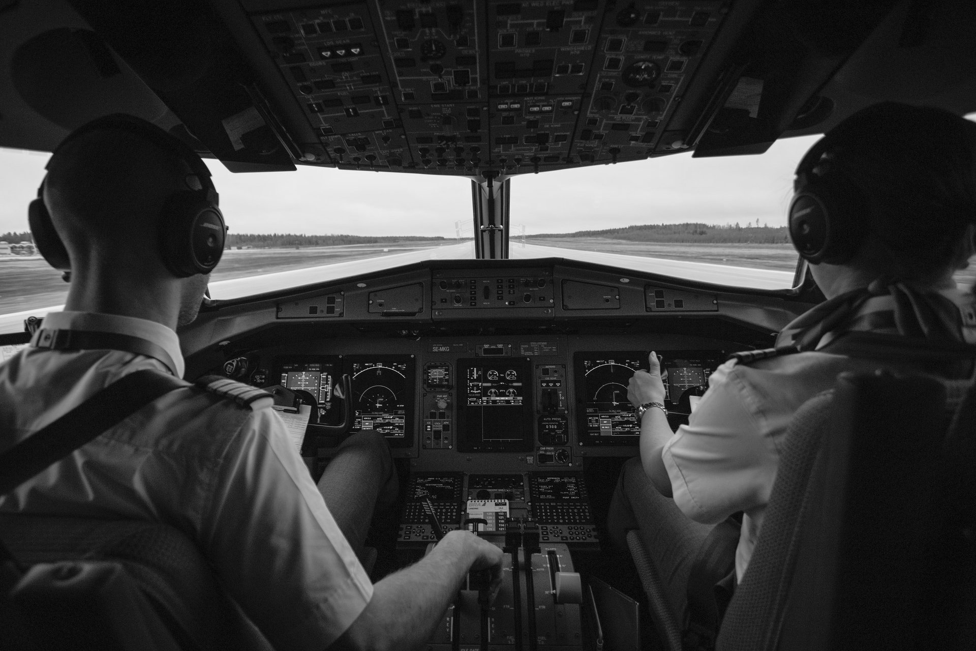 Two pilots are sitting in the cockpit of an airplane.