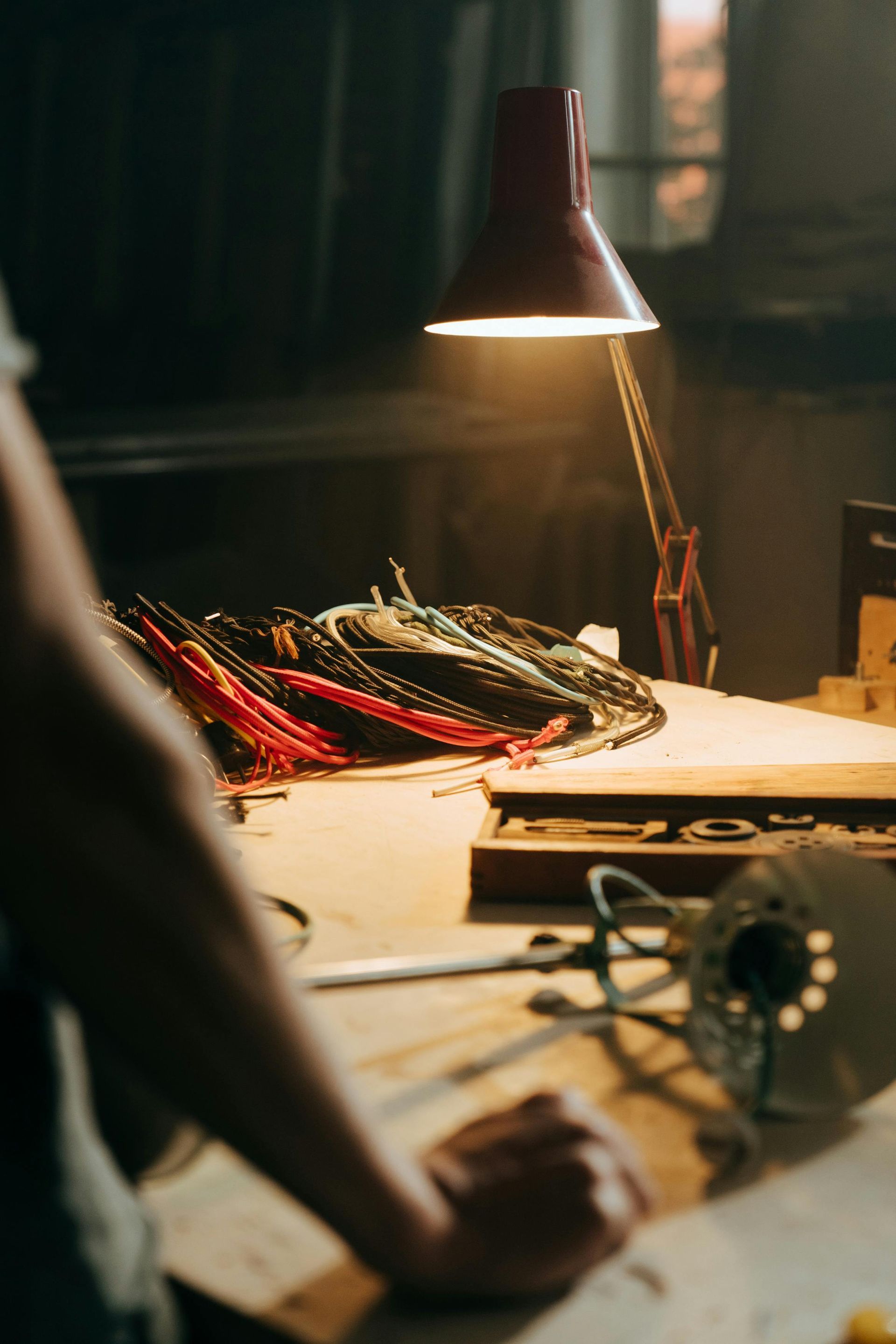 Une personne se tient devant une table avec des câbles électriques