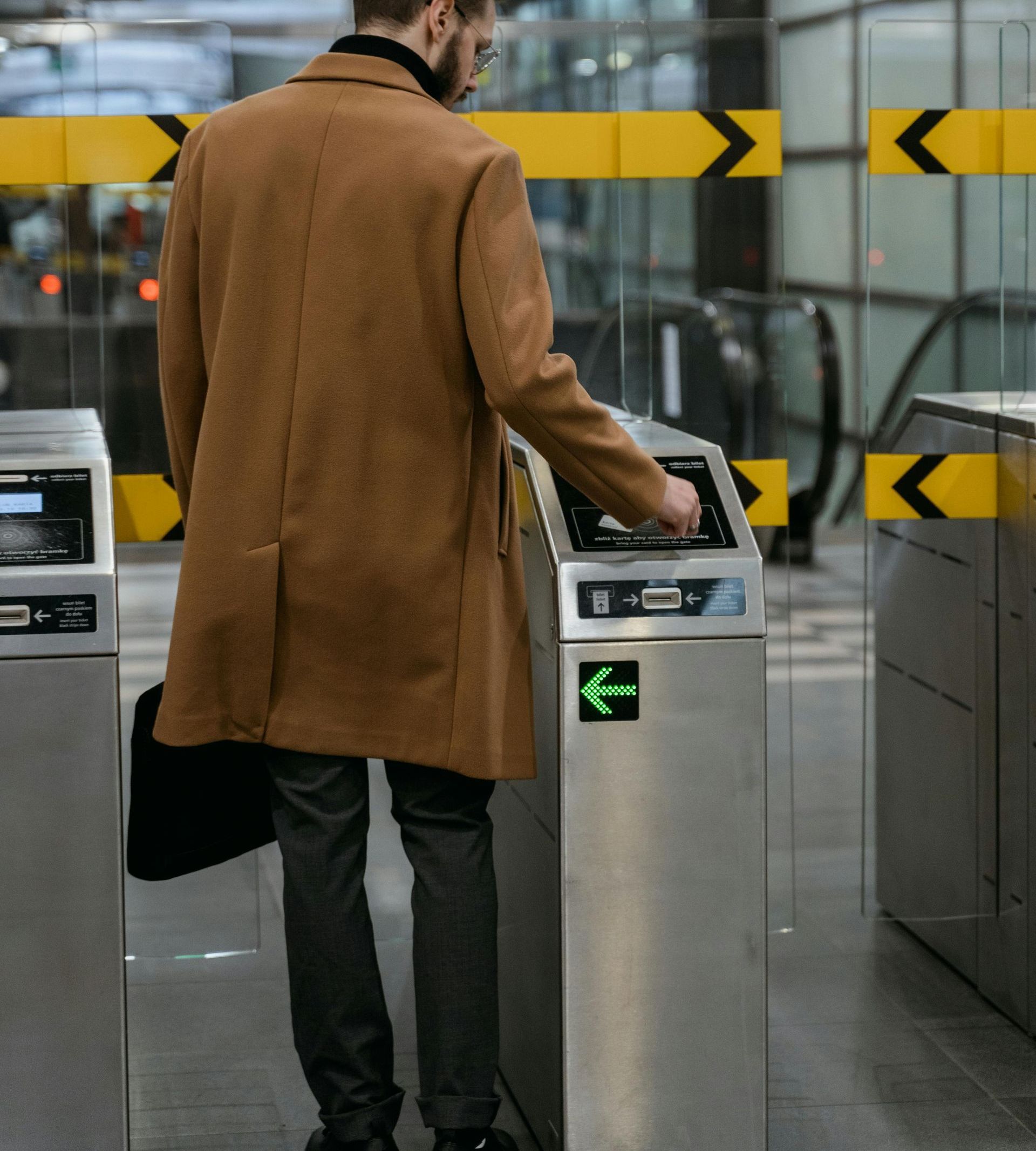Un homme en manteau marron utilise un contrôle d'accès