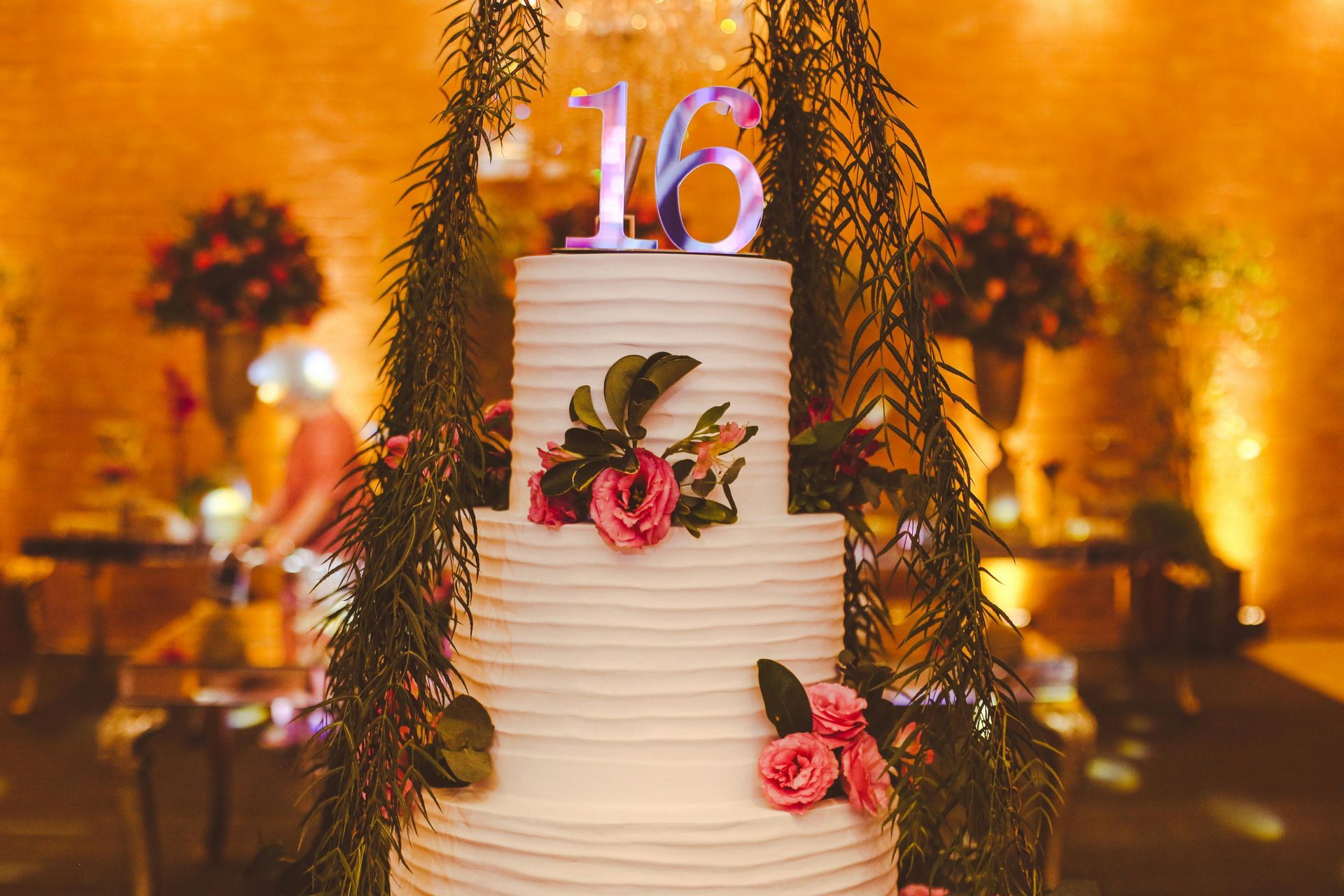 A wooden table with plates , silverware , candles and a garland.