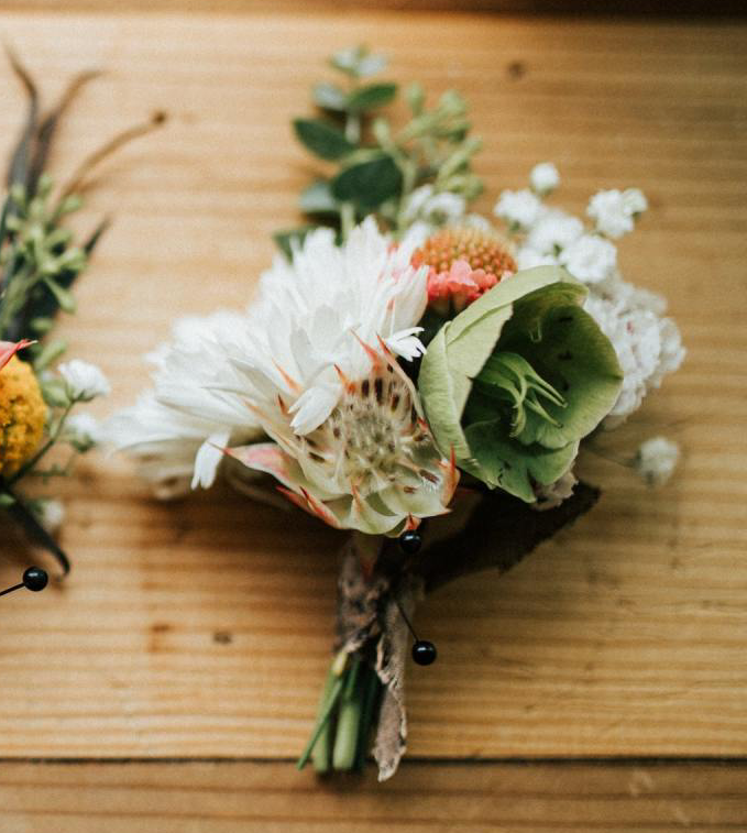 A bouquet of flowers is sitting on a wooden table.