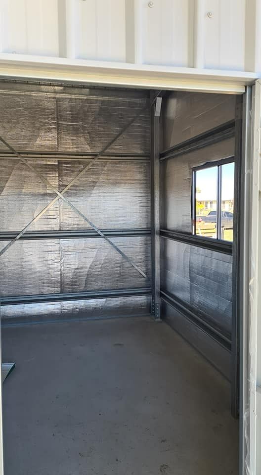 A Large Empty Room With A Door Open And A Window — Bushman Sheds in Childers, QLD