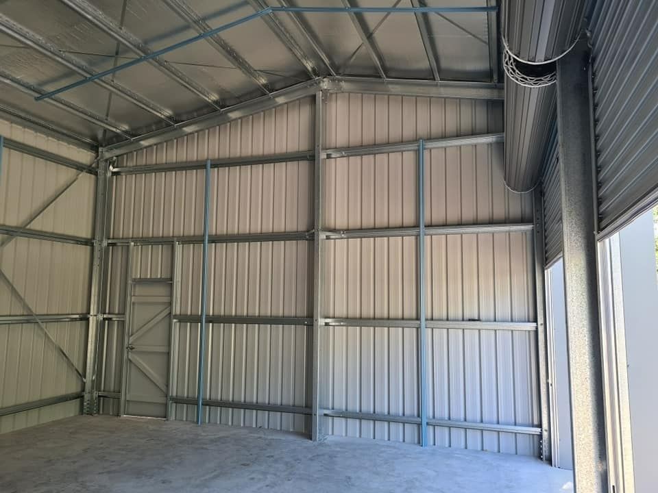 A Large Empty Warehouse With A Ceiling And A Door — Bushman Sheds in Bundaberg East, QLD