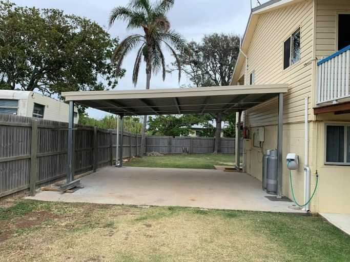 There Is A Carport In The Backyard Of A House — Bushman Sheds in Bundaberg East, QLD