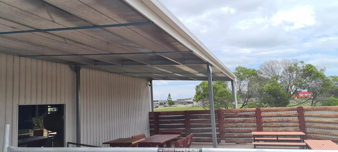 A Patio With Tables And Chairs Under A Canopy — Bushman Sheds in Bundaberg East, QLD