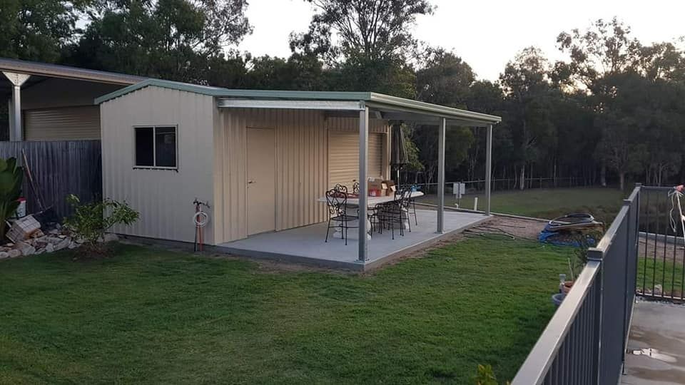 A Shed With A Porch And A Table And Chairs In A Backyard — Bushman Sheds in Bundaberg East, QLD