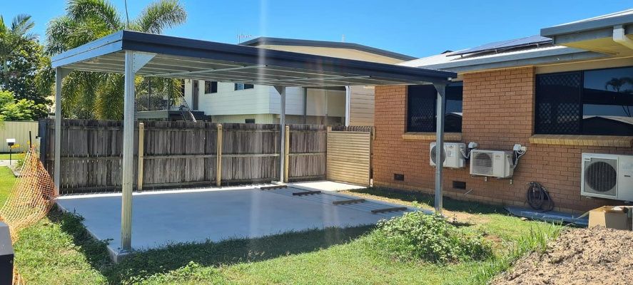 There Is A Carport In The Backyard Of A House — Bushman Sheds in Bundaberg East, QLD