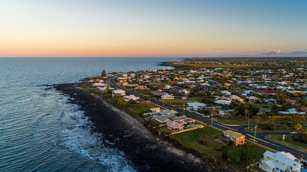 An Aerial View Of A City Next To The Ocean At Sunset — Bushman Sheds in Bundaberg, QLD