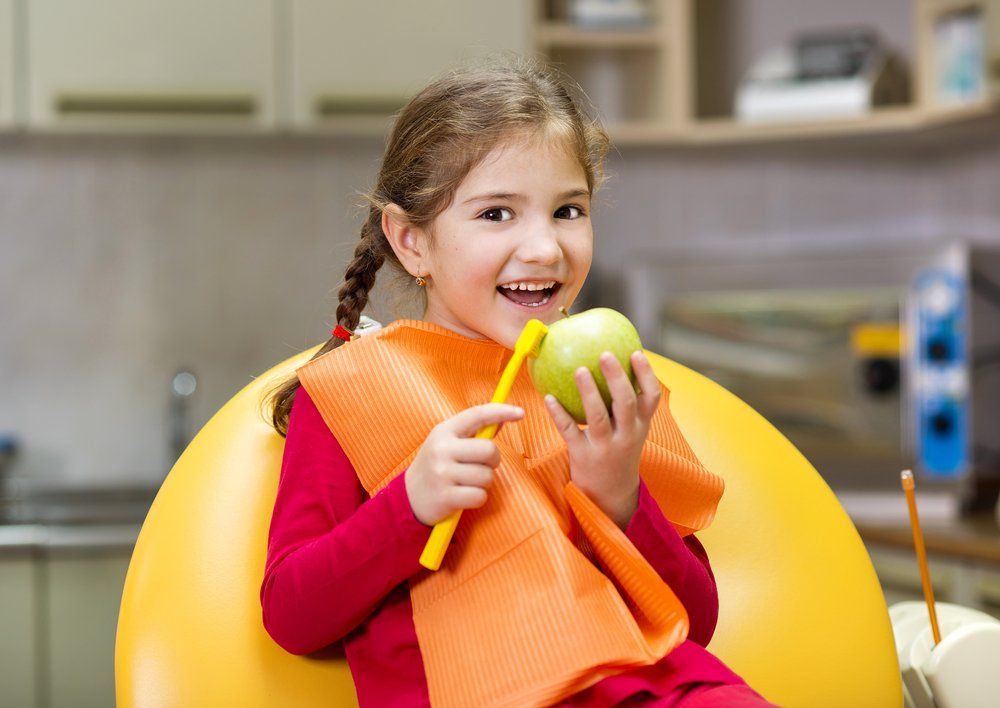 Little Girl Brushing Apple — Dentistry Services in Cairns, QLD