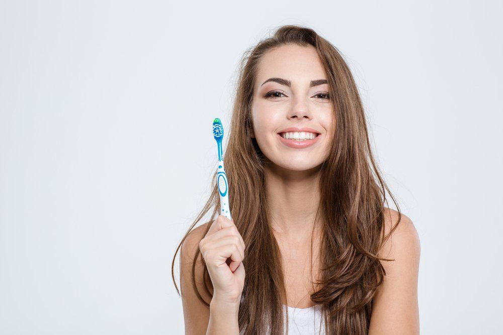 Woman Holding Toothbrush — Dentistry Services in Cairns, QLD