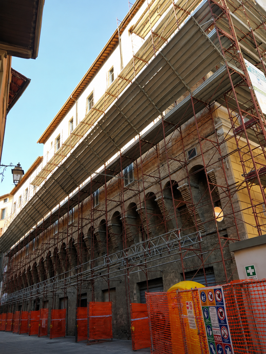Edificio cilindrico in costruzione, con impalcature, sullo sfondo di un cielo azzurro.