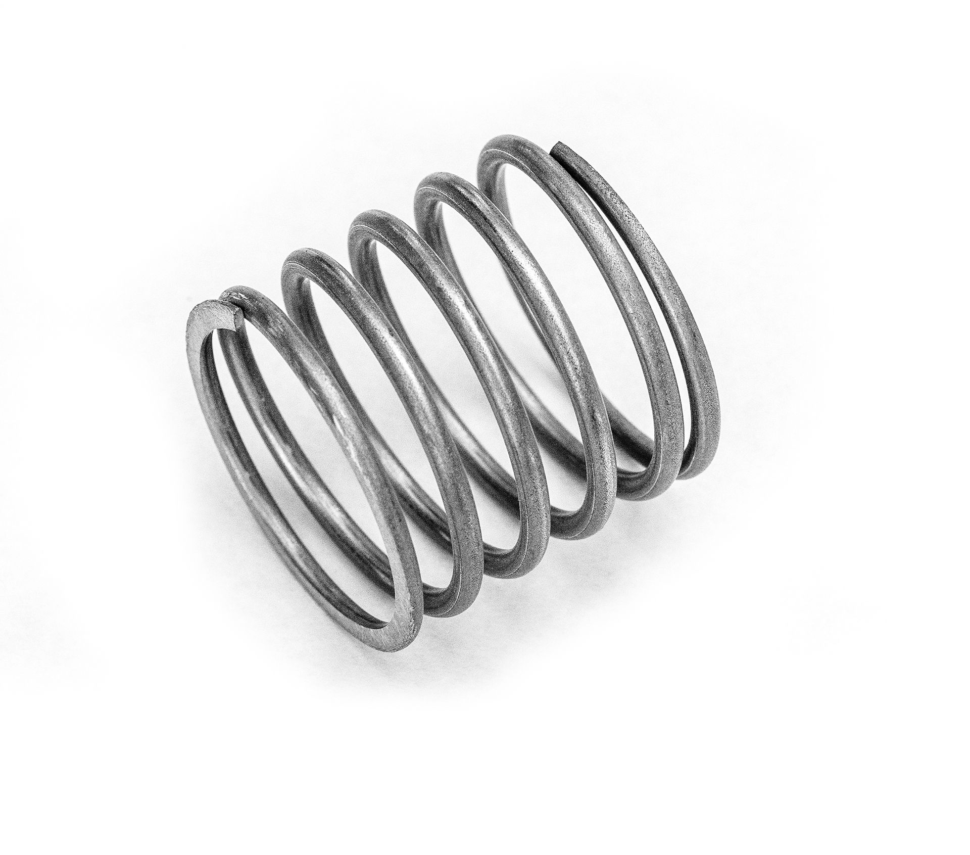 Coiled metal spring, grey, on a white background.