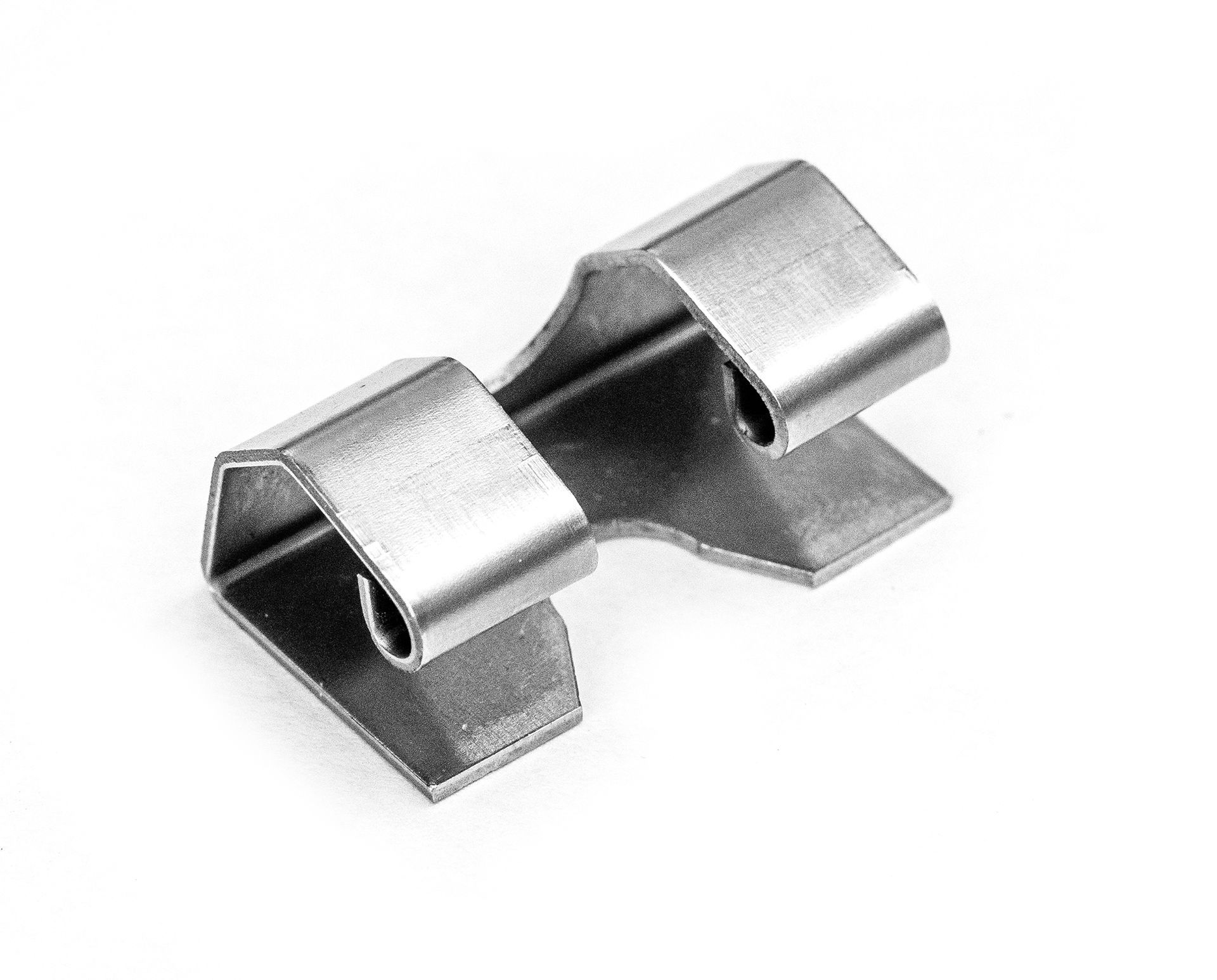 Metal clip, silver, with two curved arms connected by a flat section, on a white background.