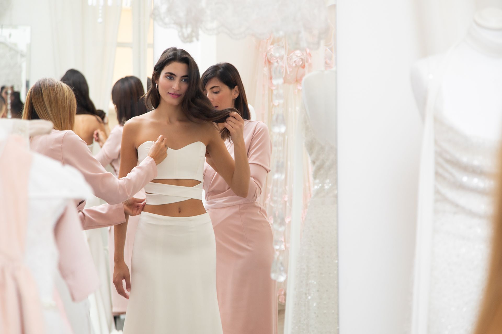 Una donna sta provando un abito da sposa in un negozio.