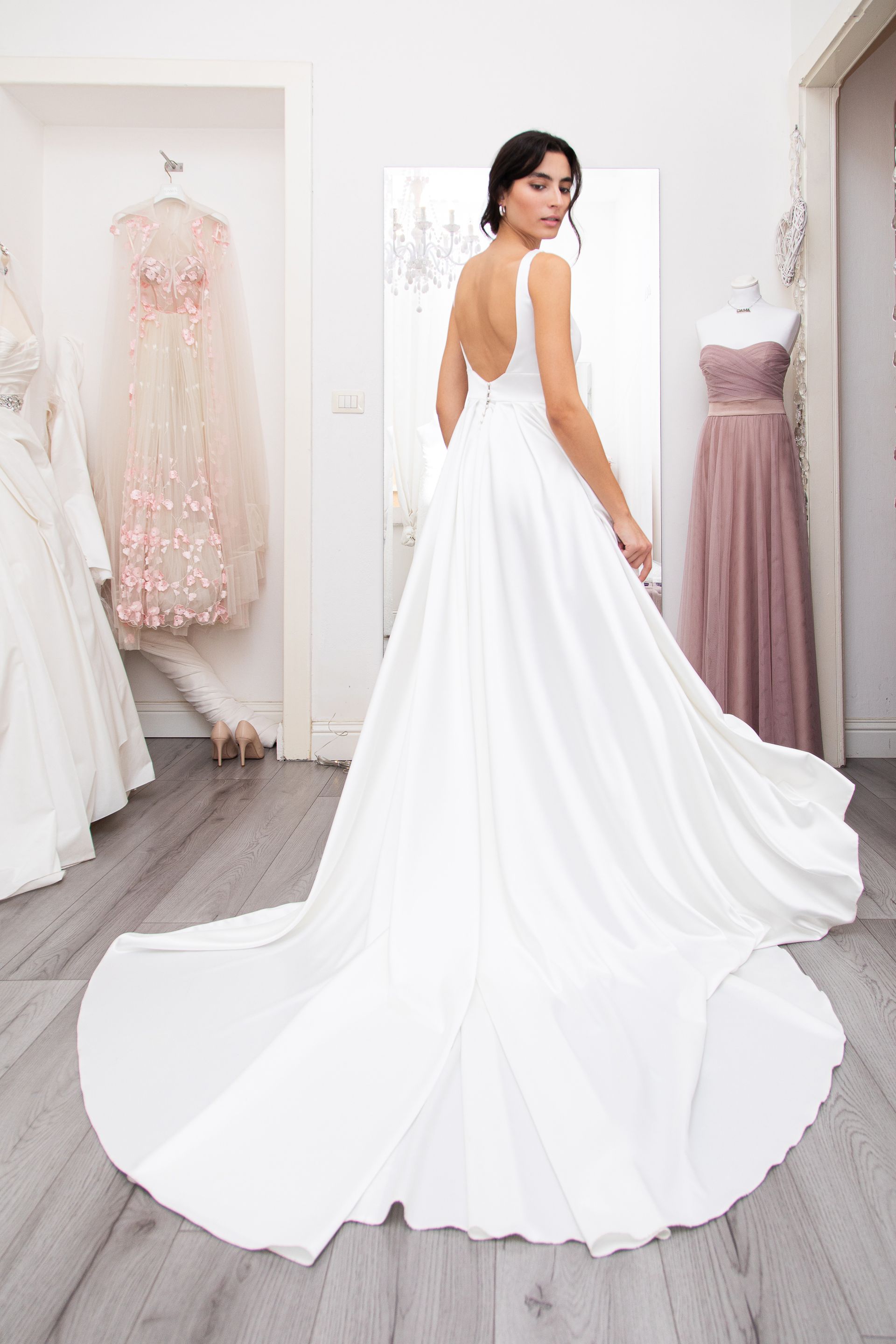 Una donna indossa un abito da sposa bianco in un negozio di abiti da sposa.