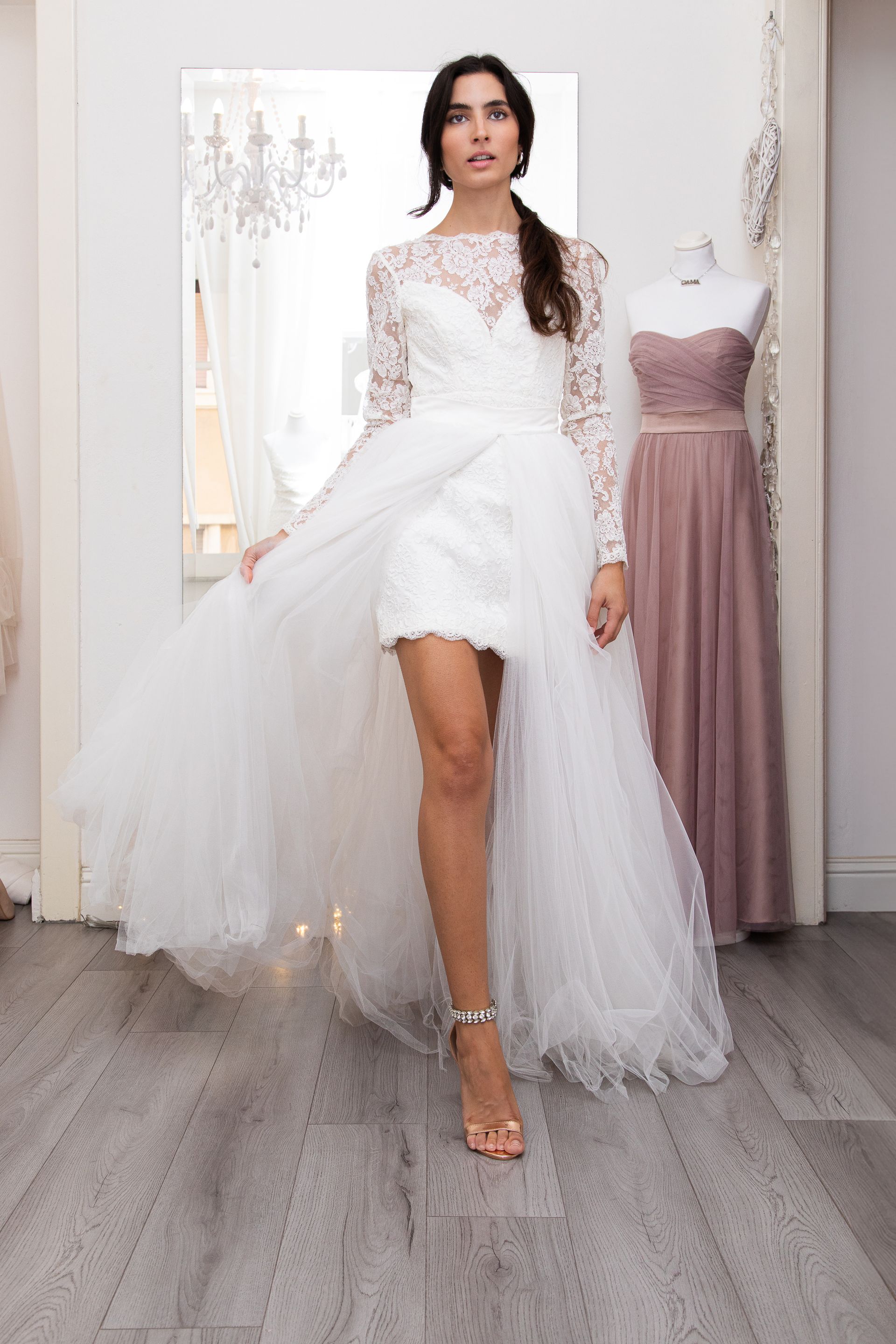 Una donna in abito da sposa bianco è in piedi in una stanza.