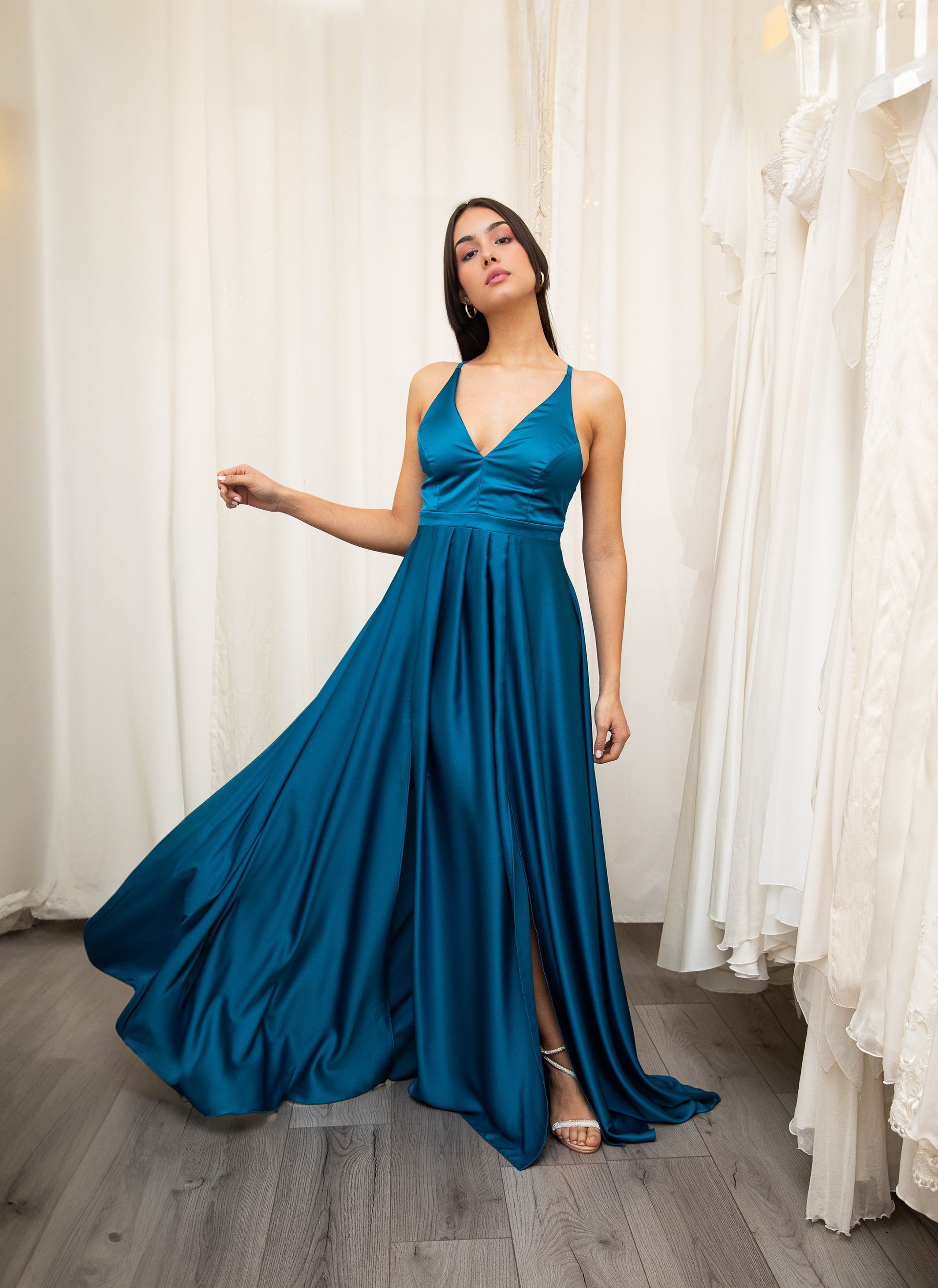 Una donna indossa un abito di raso blu con una profonda scollatura.