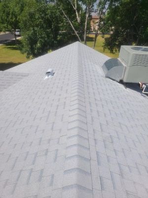 A roof with a fan on top of it and trees in the background.