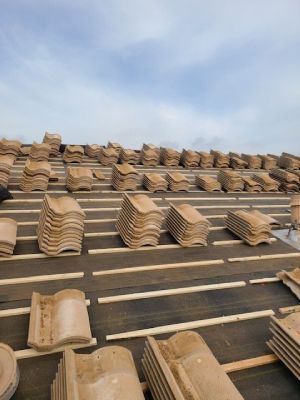 A lot of tiles are stacked on top of each other on a roof.