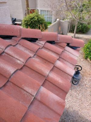 A red tile roof with a lantern on the side of it.