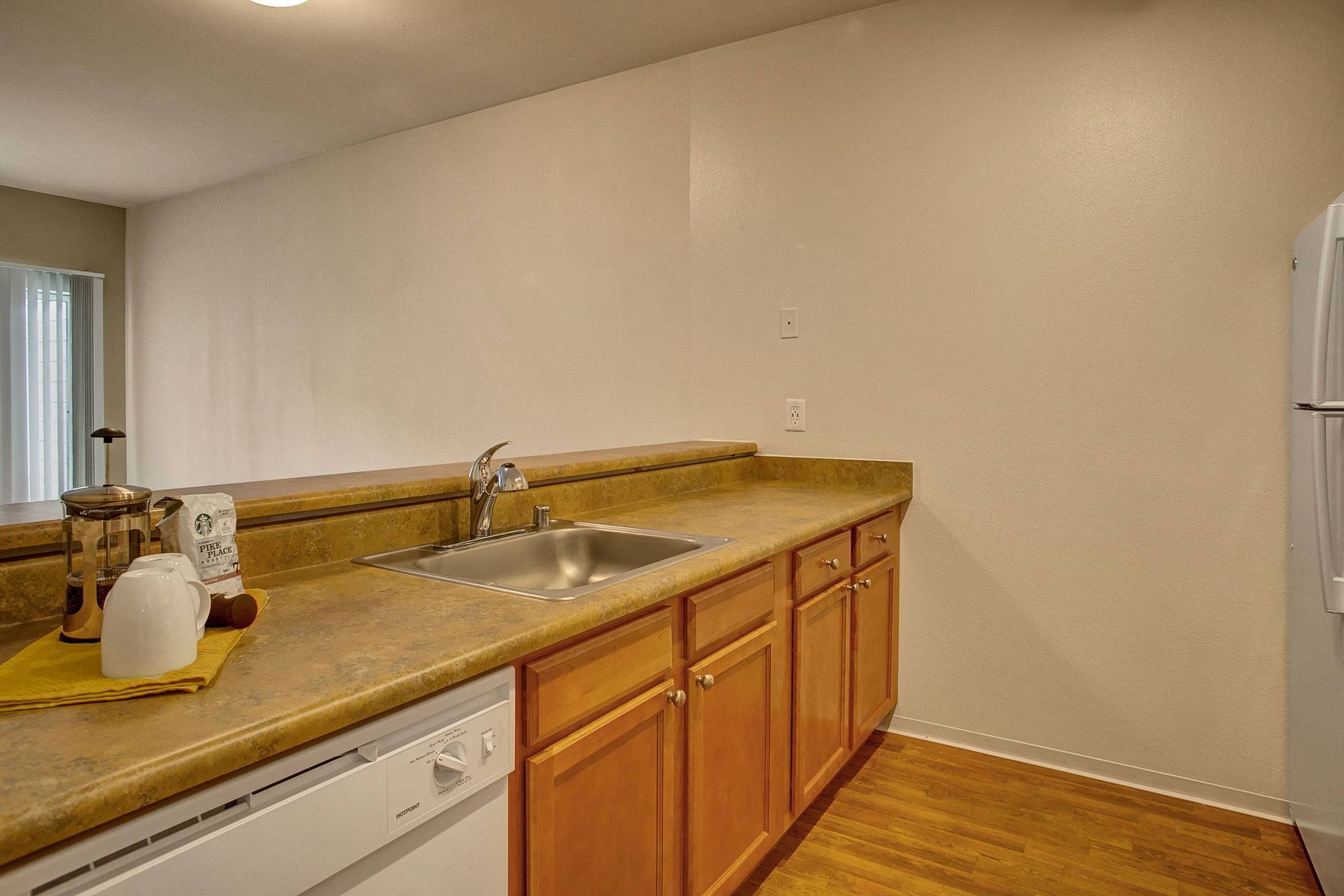 A kitchen with a sink, dishwasher, and refrigerator.