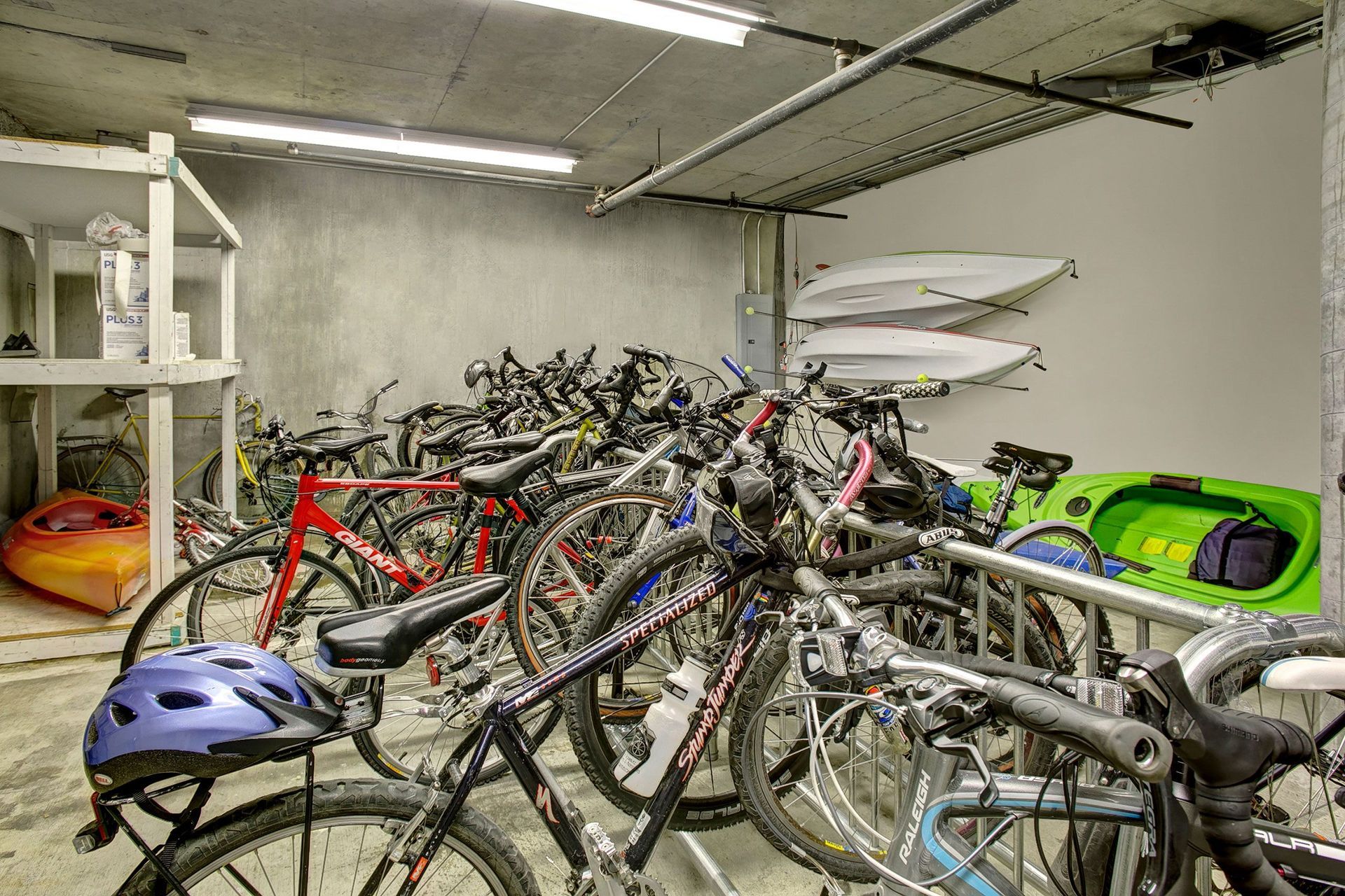 A bunch of bikes are parked in a garage.