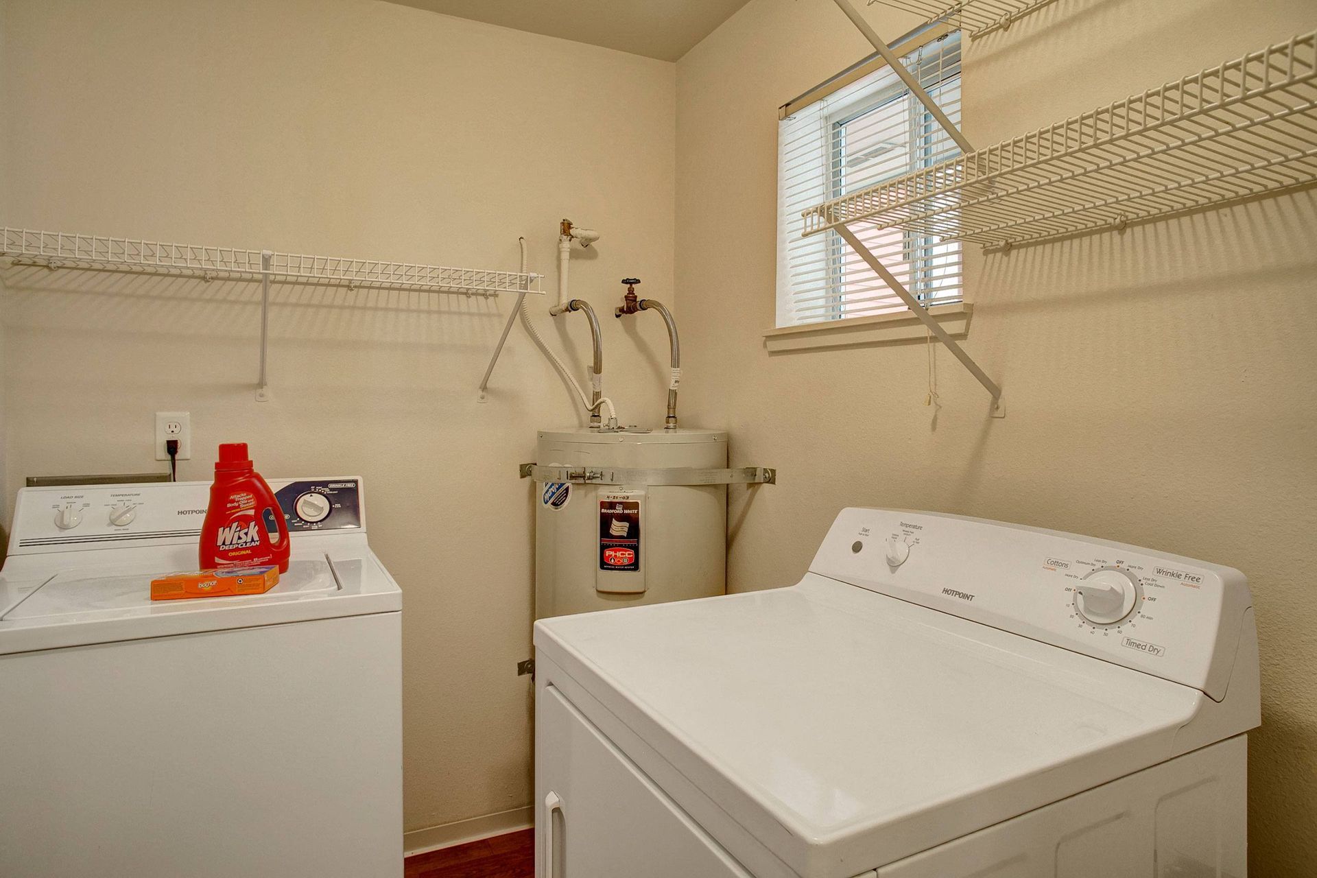 A laundry room with a washer and dryer and a water heater.