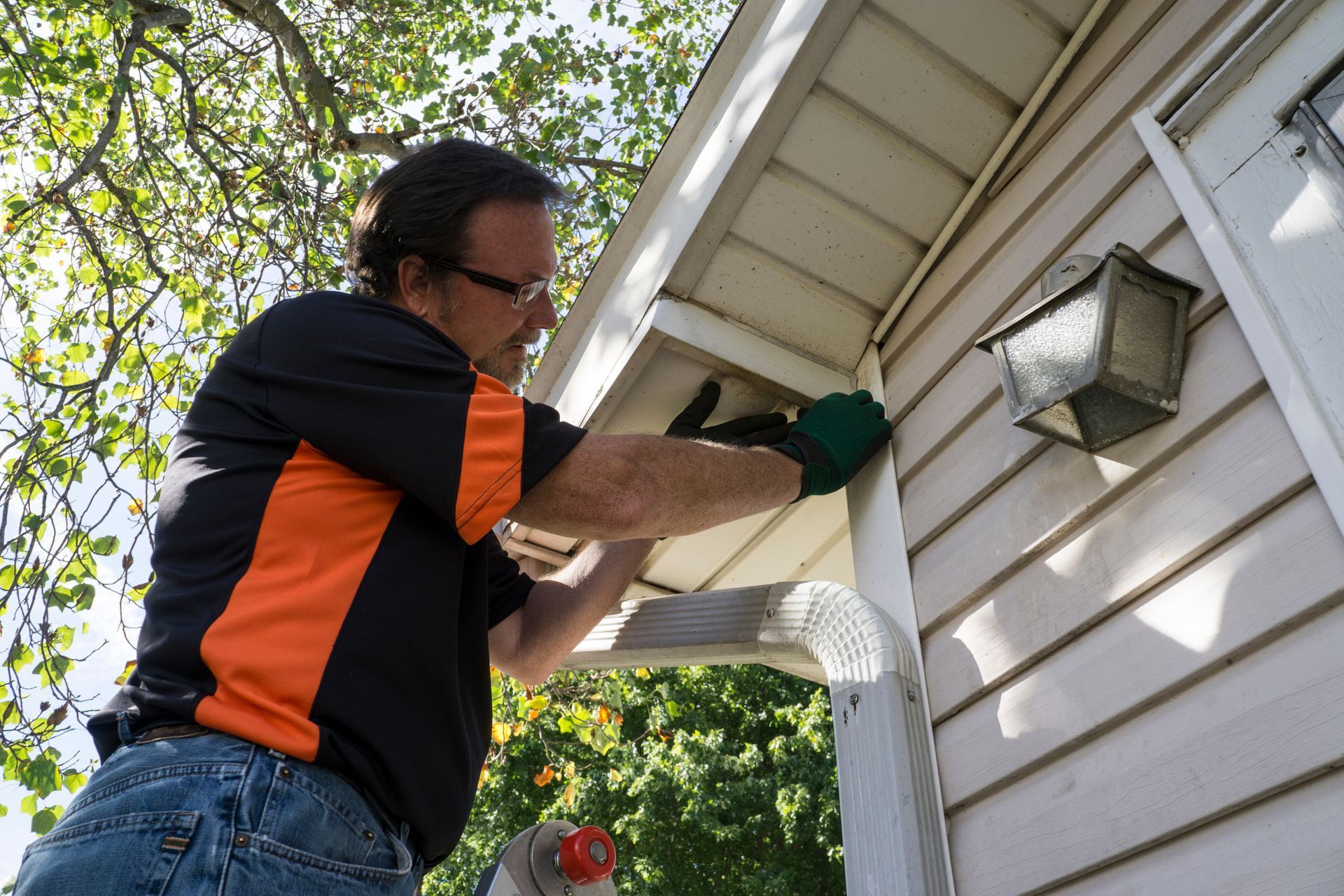 Handyman installing new siding on the exterior of a house.