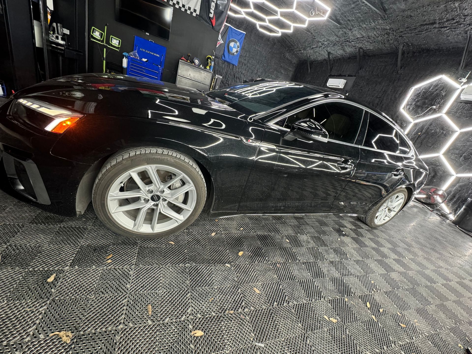 A black car is parked in a garage.