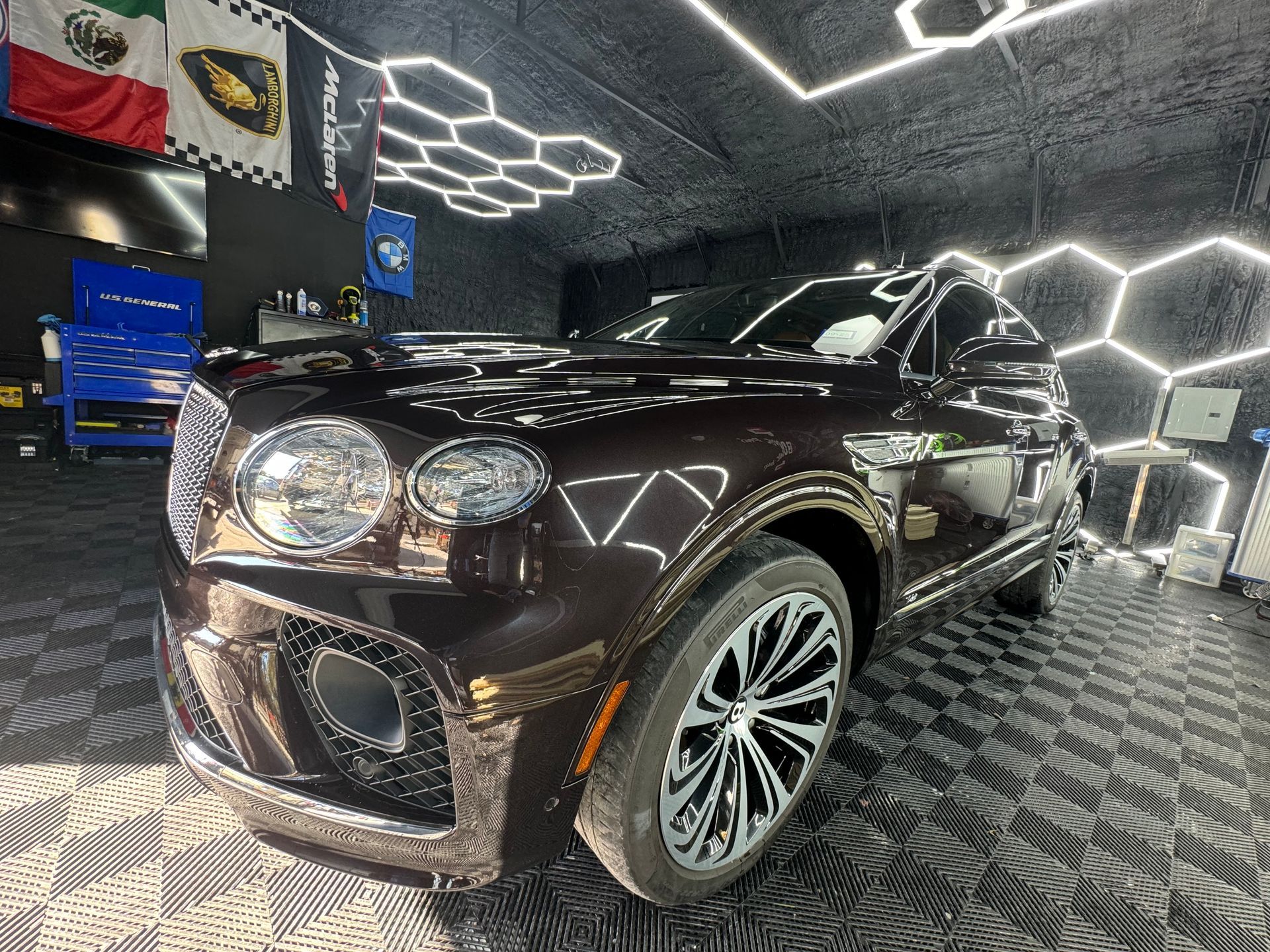 A black bentley is parked in a garage.