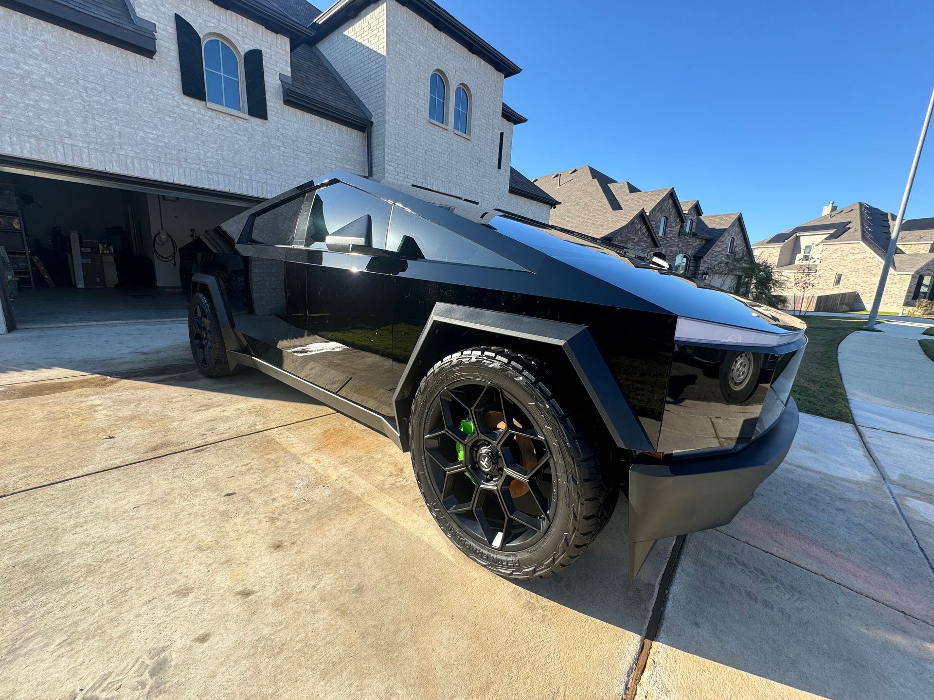 A black car is parked in front of a house.