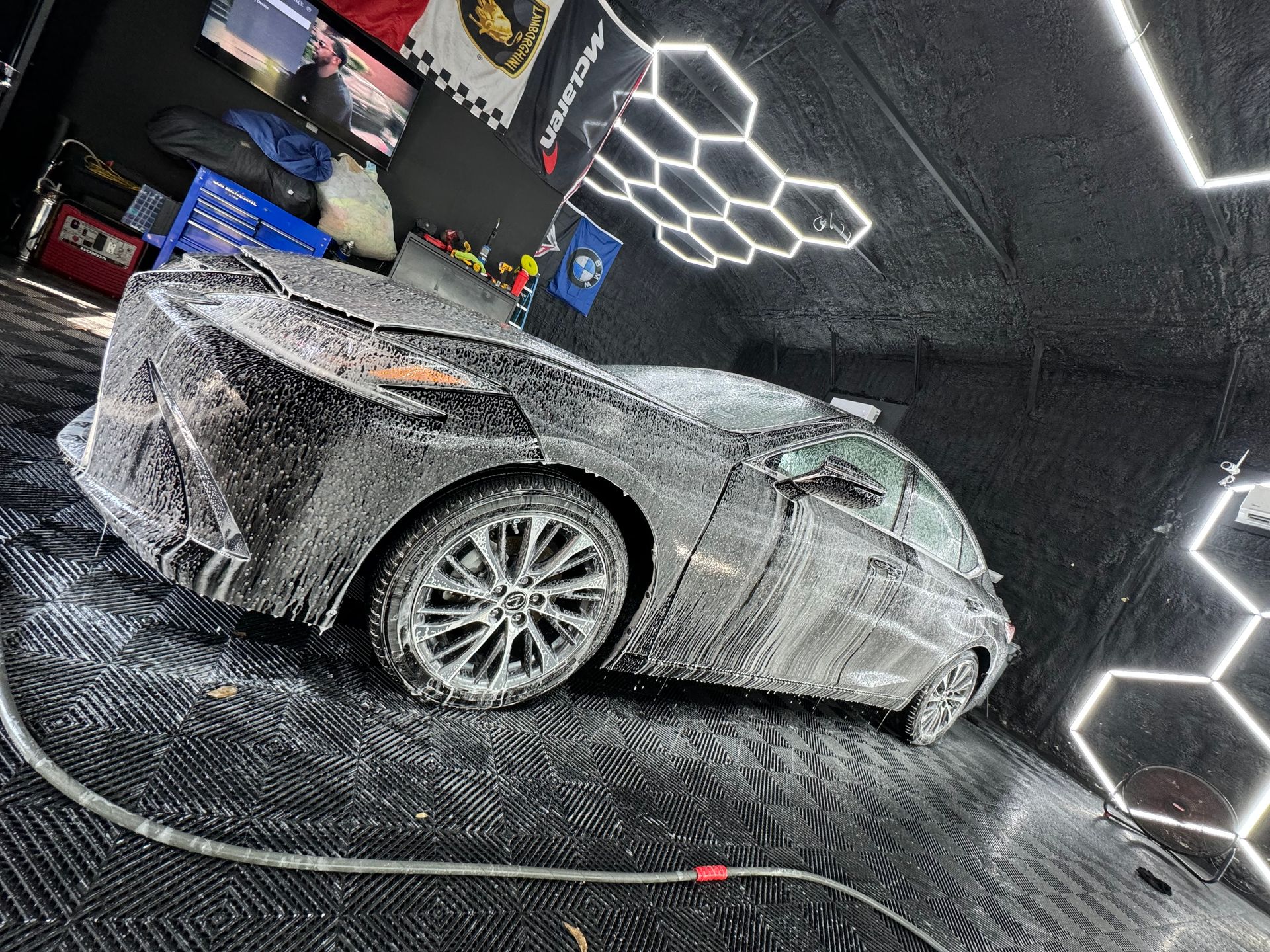 A car is covered in foam in a garage.