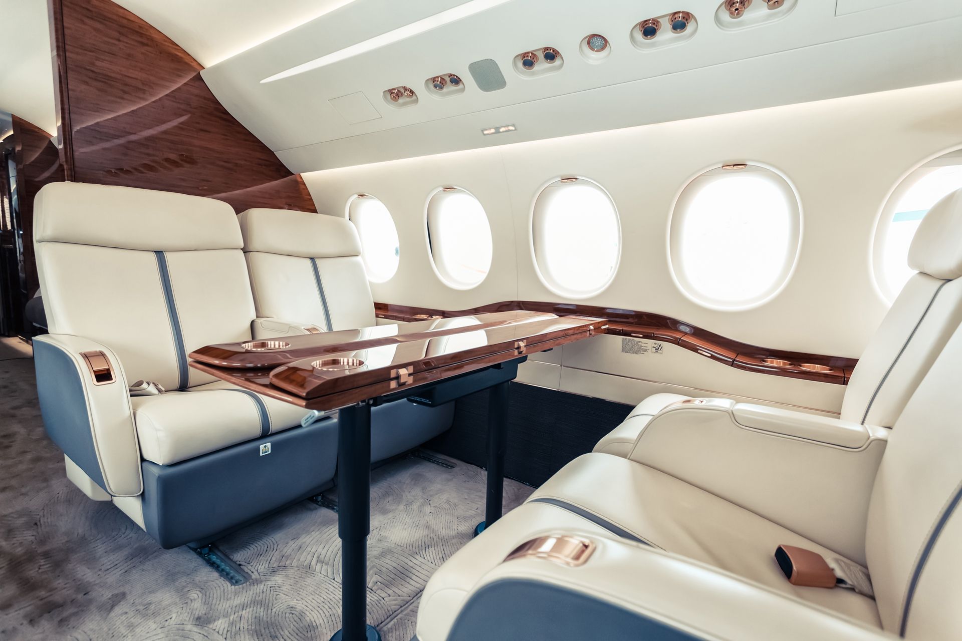 The inside of a private jet with a table and chairs.