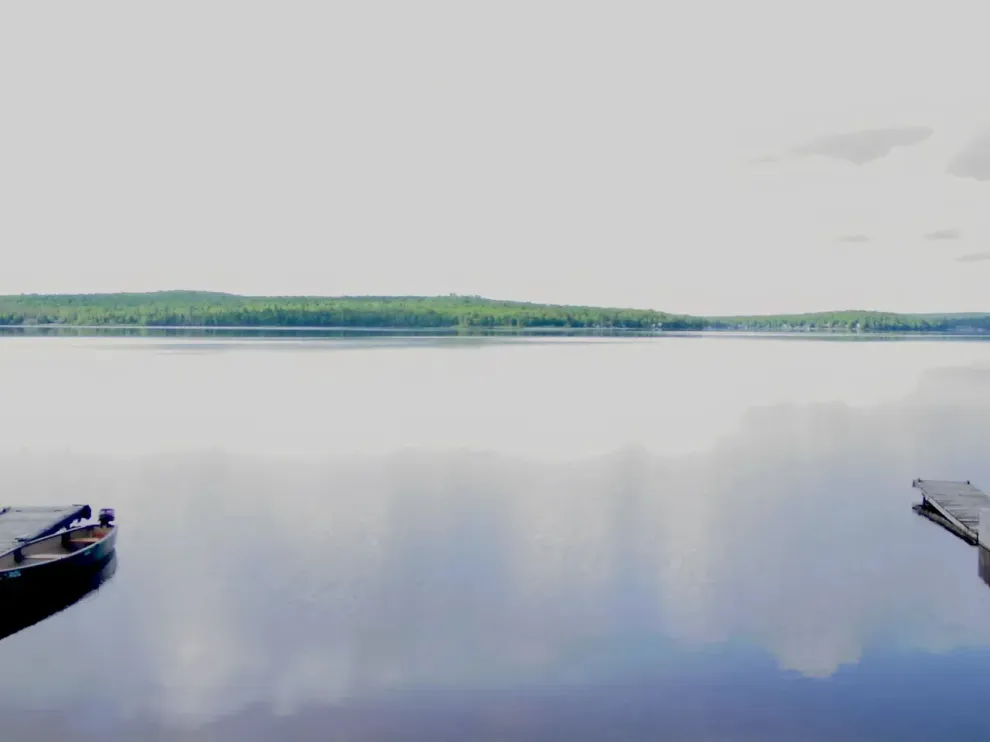 two boats are floating on top of a large body of water .