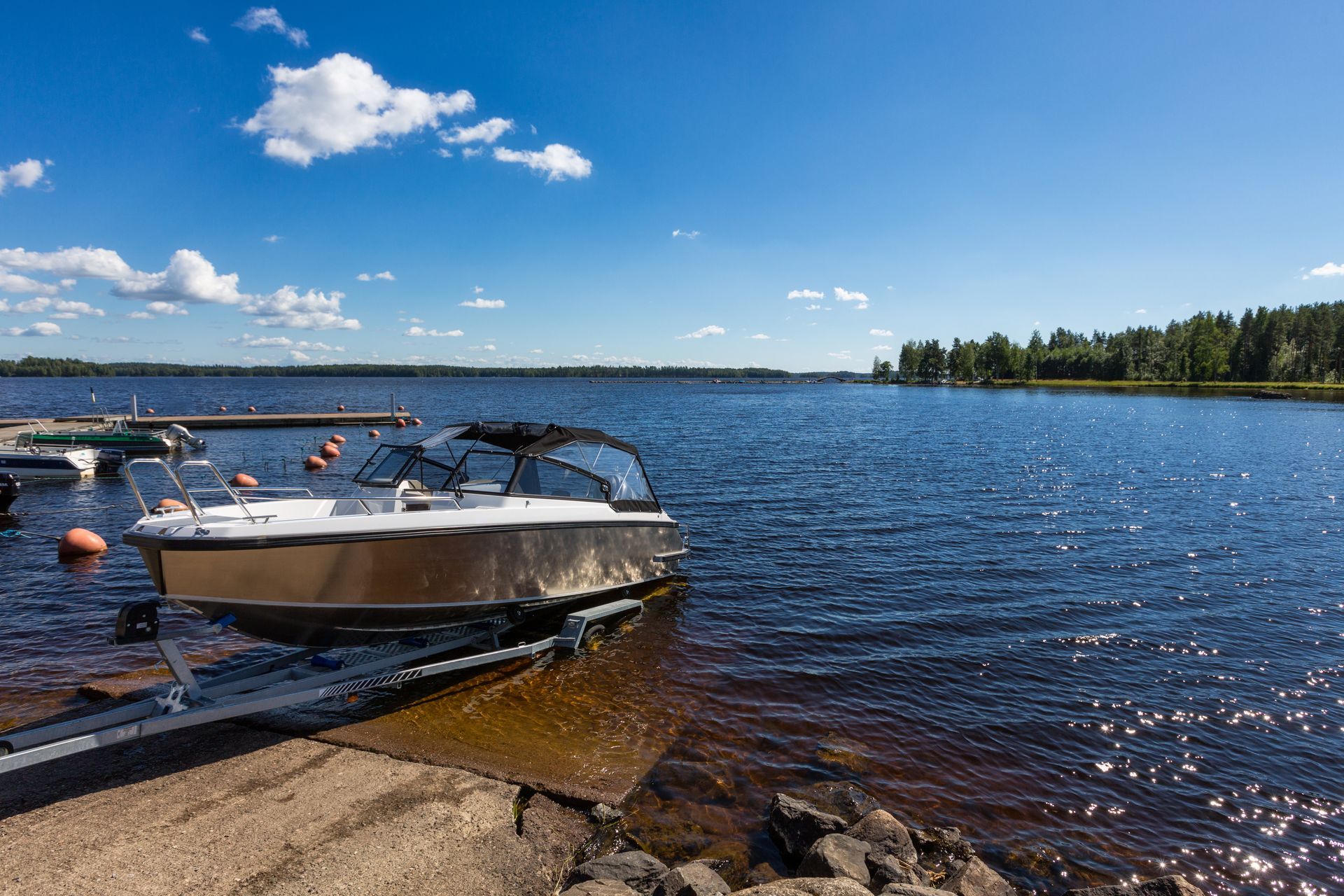 a boat is docked on the shore of a lake .