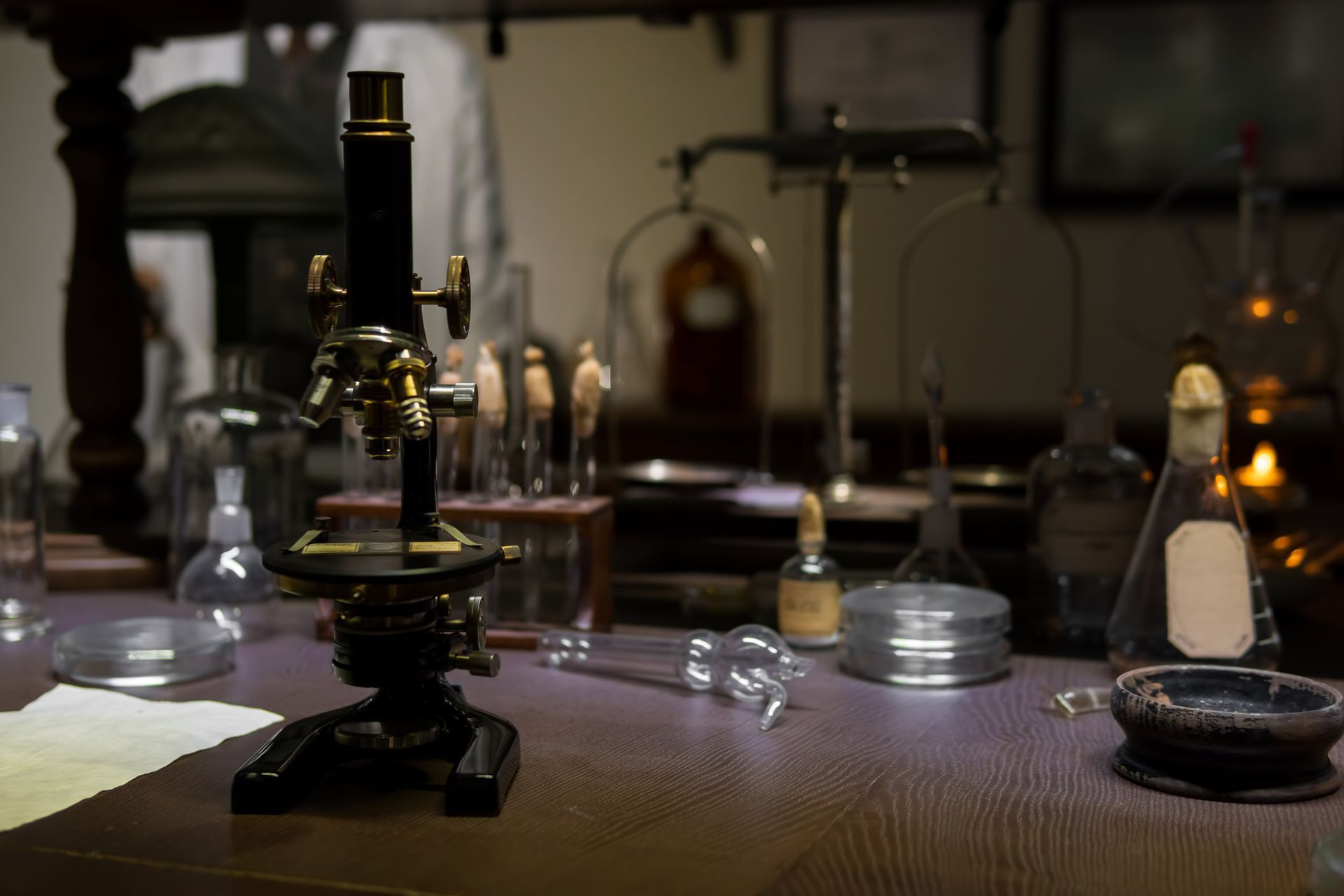 a microscope is sitting on top of a wooden table in a laboratory .