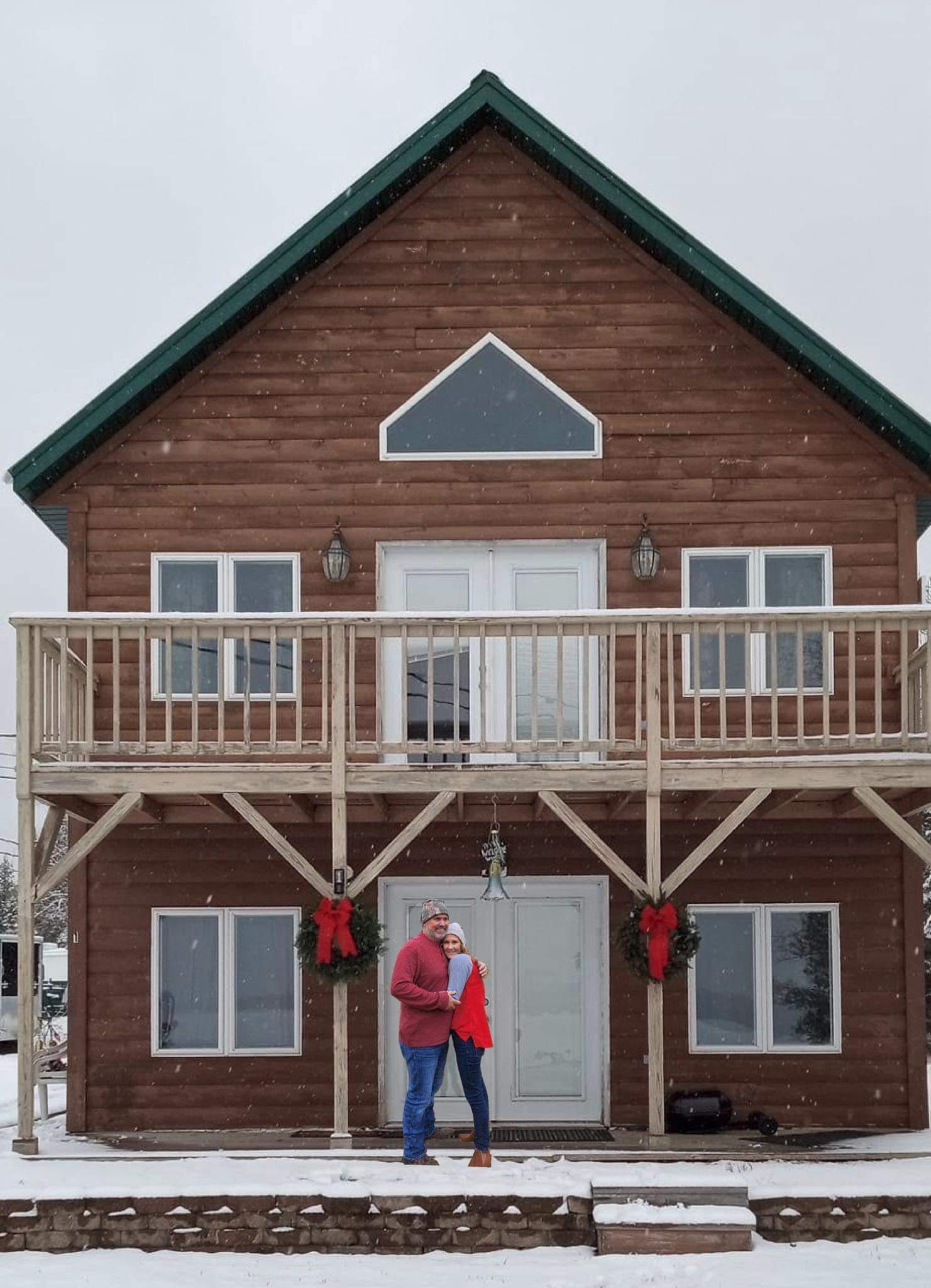 a large brown house with a green roof and a balcony